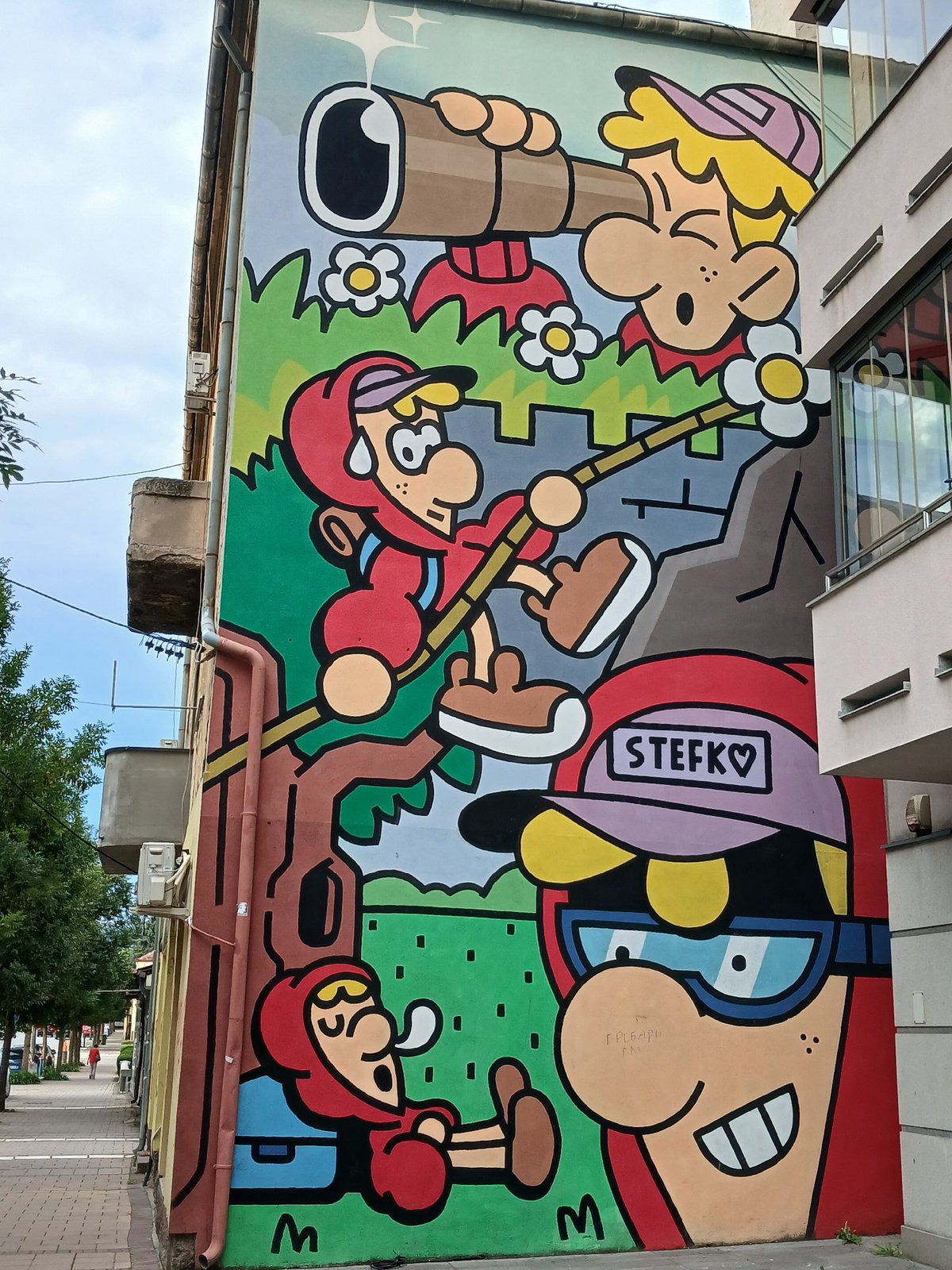 Vibrant cartoon mural covers the exterior of a multi-story building