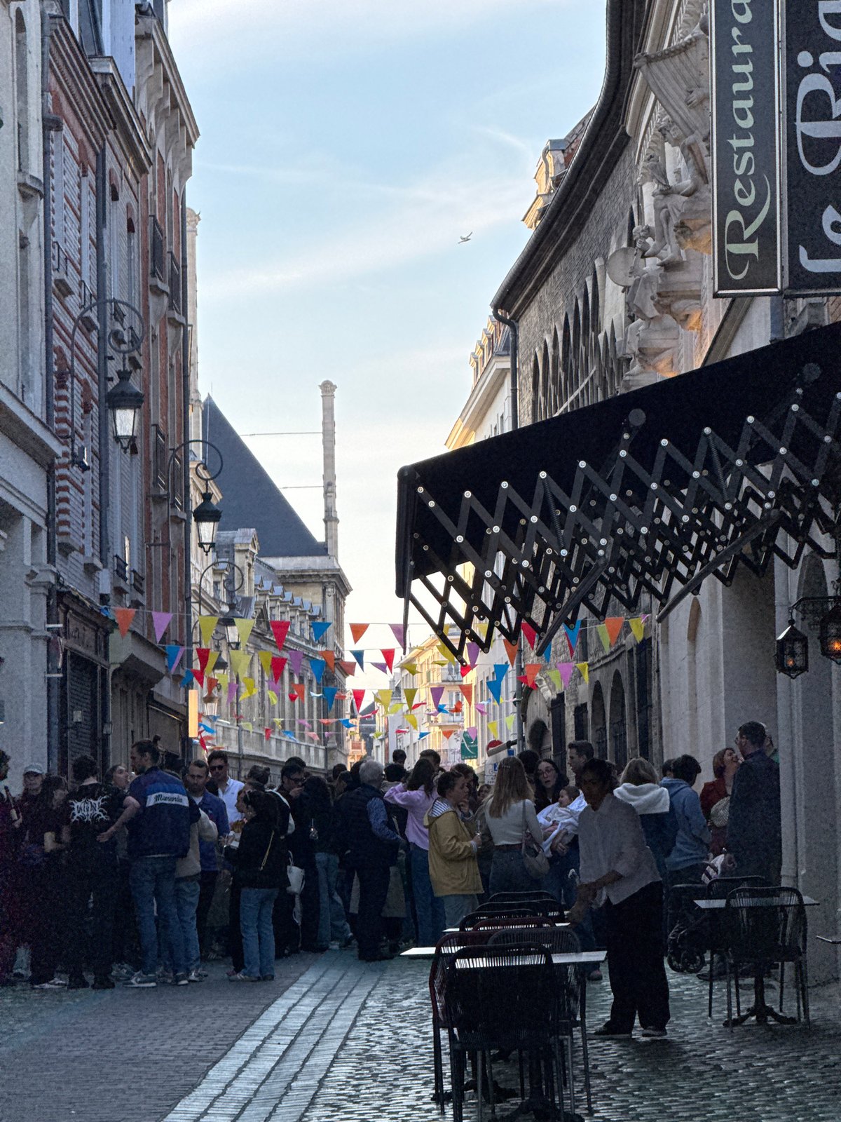 Crowd gathers on pedestrian street in Reims, France