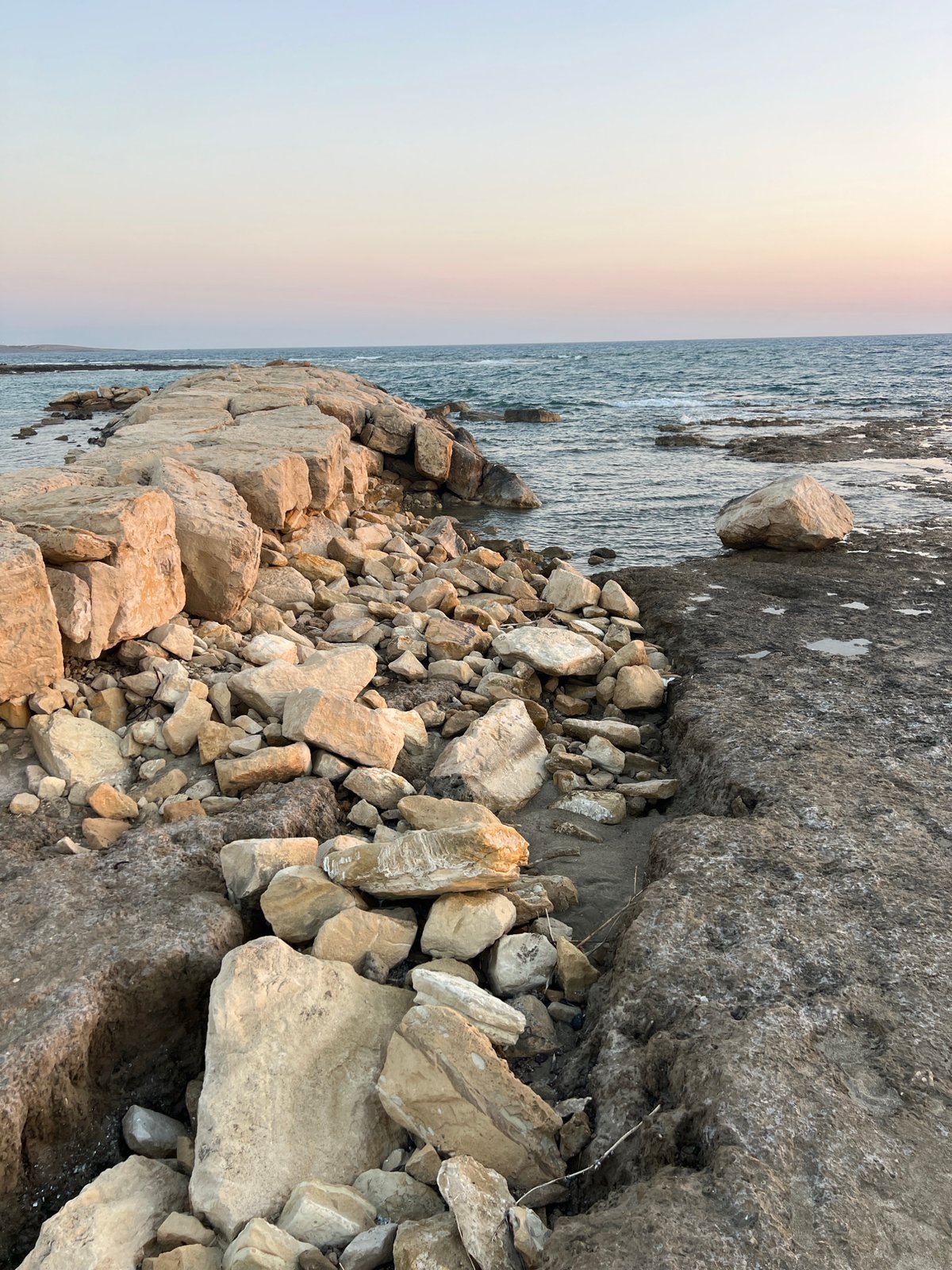 Akrotiri's rocky coast and harbor on a July afternoon