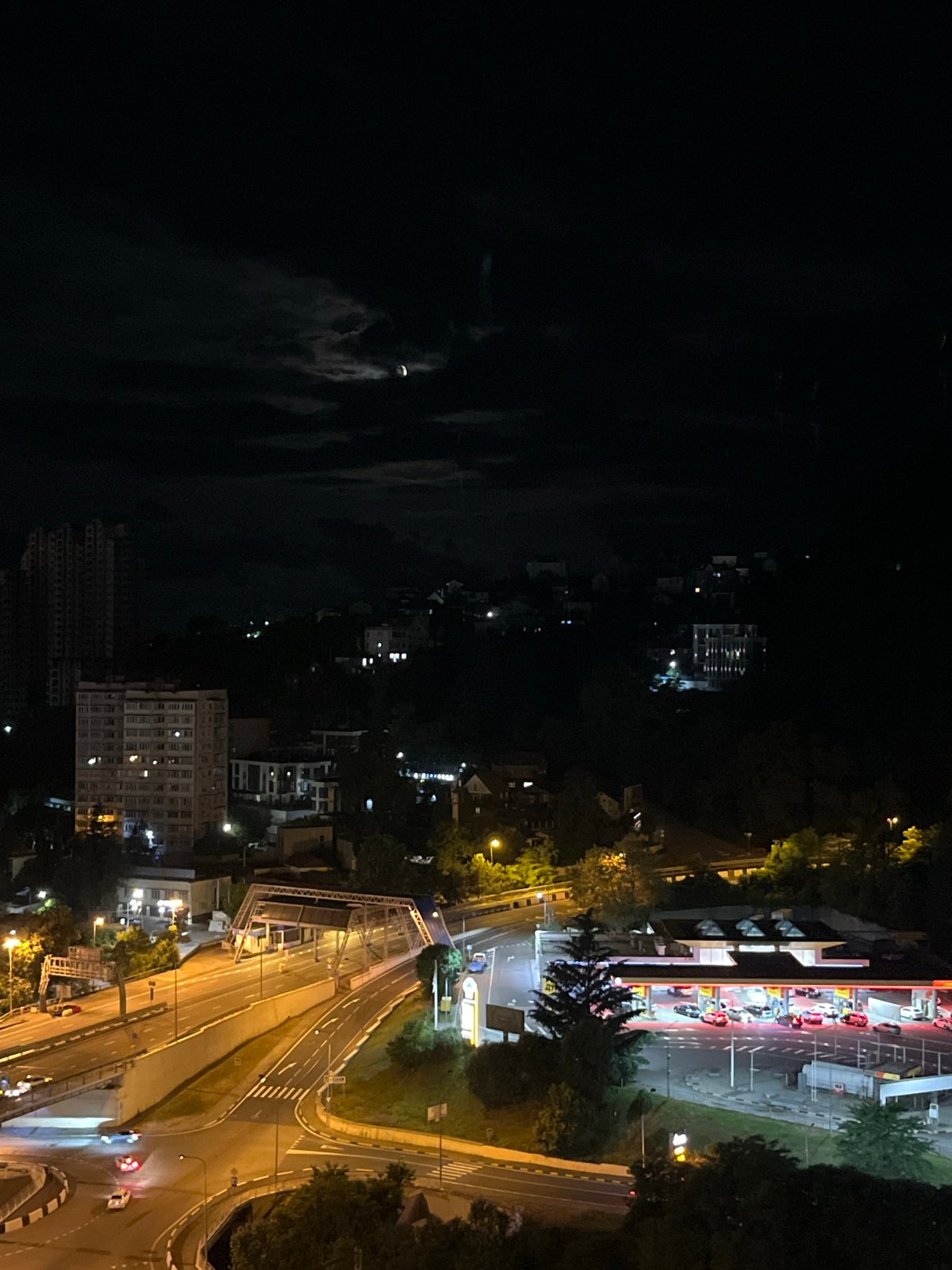 Sochi at night from above: highways, towers, and a crescent moon