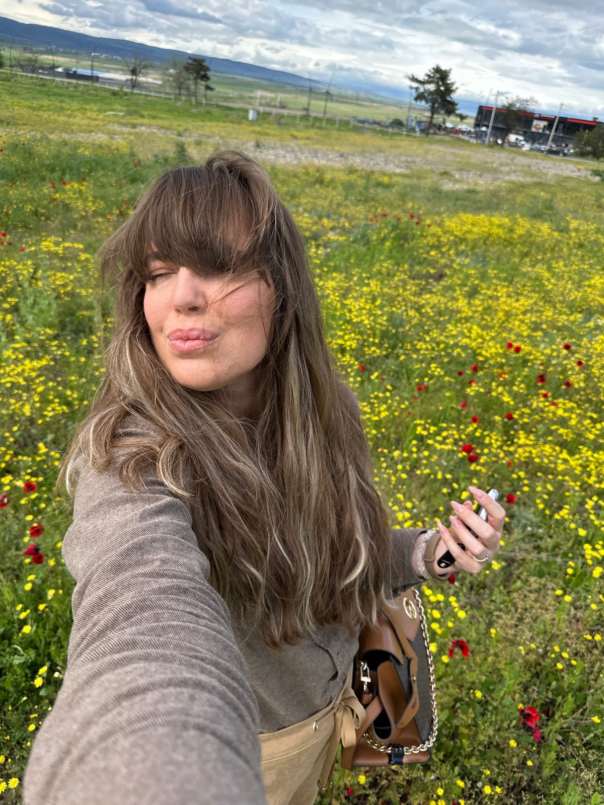 Woman takes selfies in wildflower field near Marneuli, Georgia
