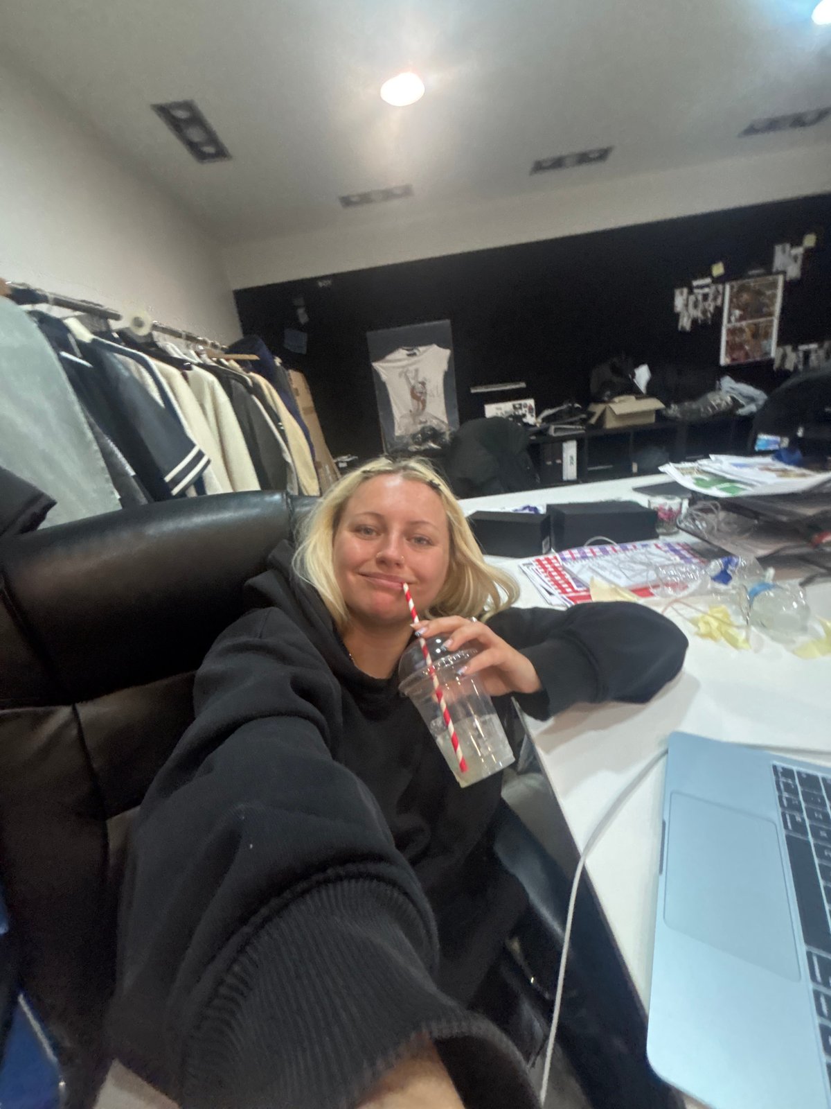 Woman relaxes with drink and laptop in London home
