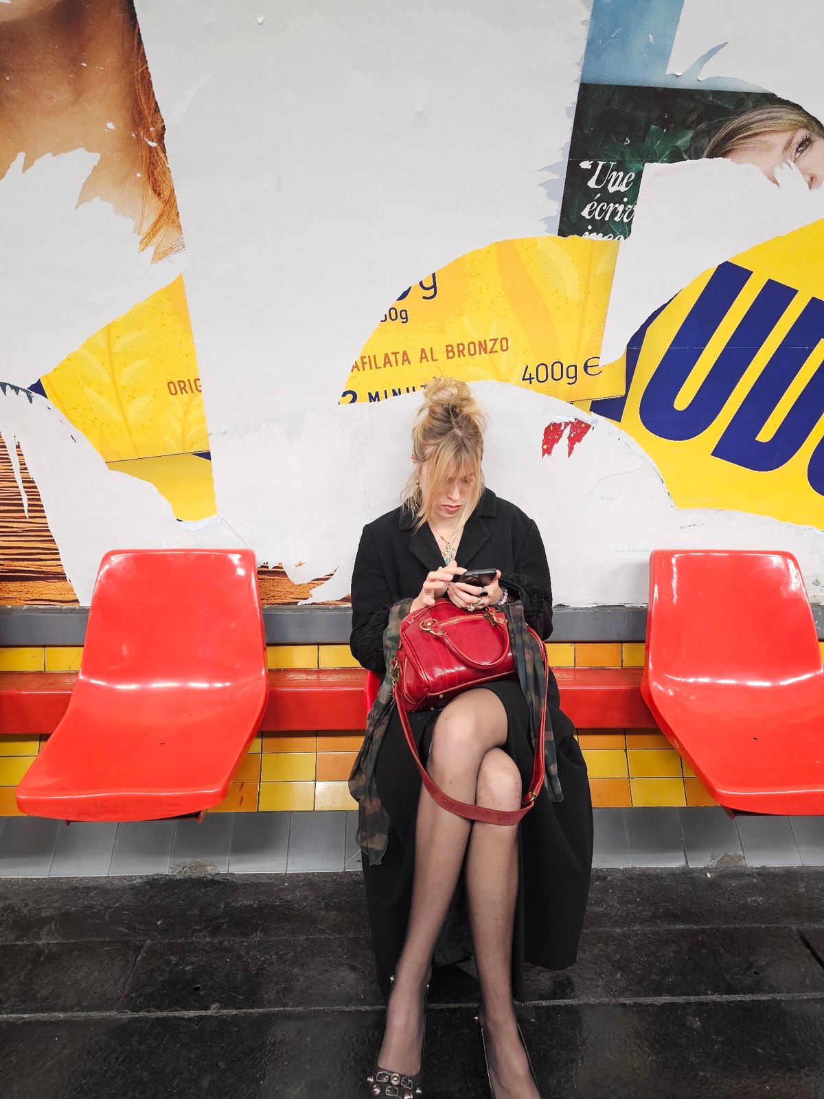 Woman uses smartphone in Paris Metro station late night