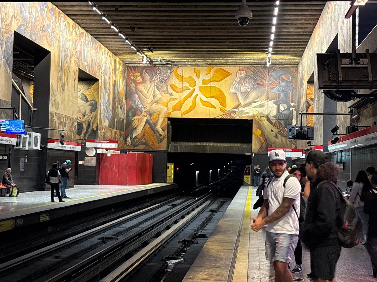 Evening commuters gather at mural-decorated Santiago metro station