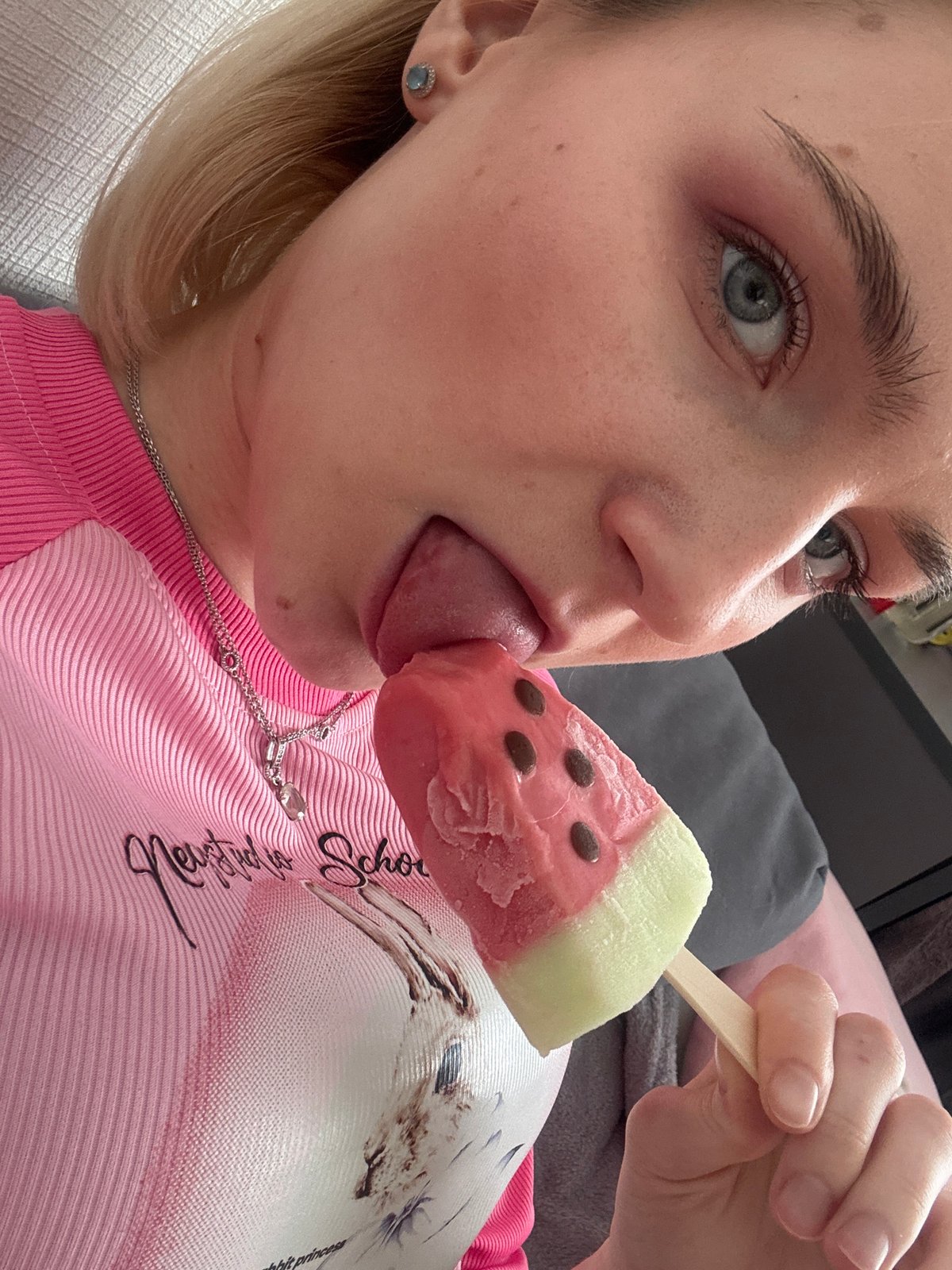 Young person enjoys watermelon popsicle indoors