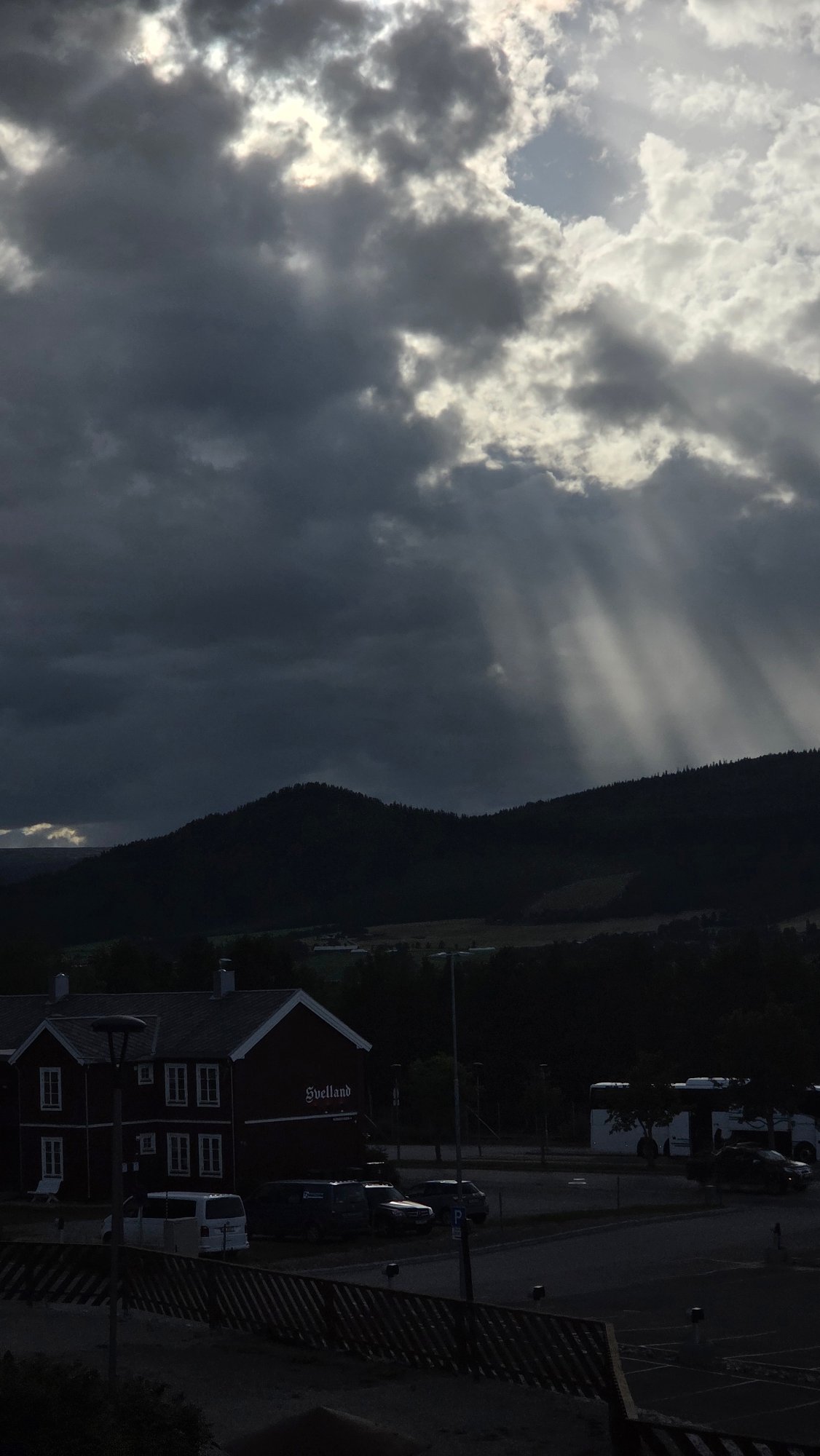 Dramatic light breaks over Tynset's rural landscape and church