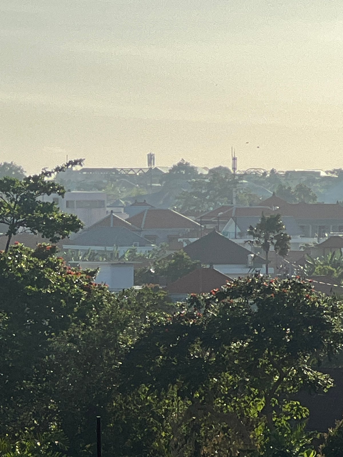 Resident washes scooter in tropical North Kuta morning