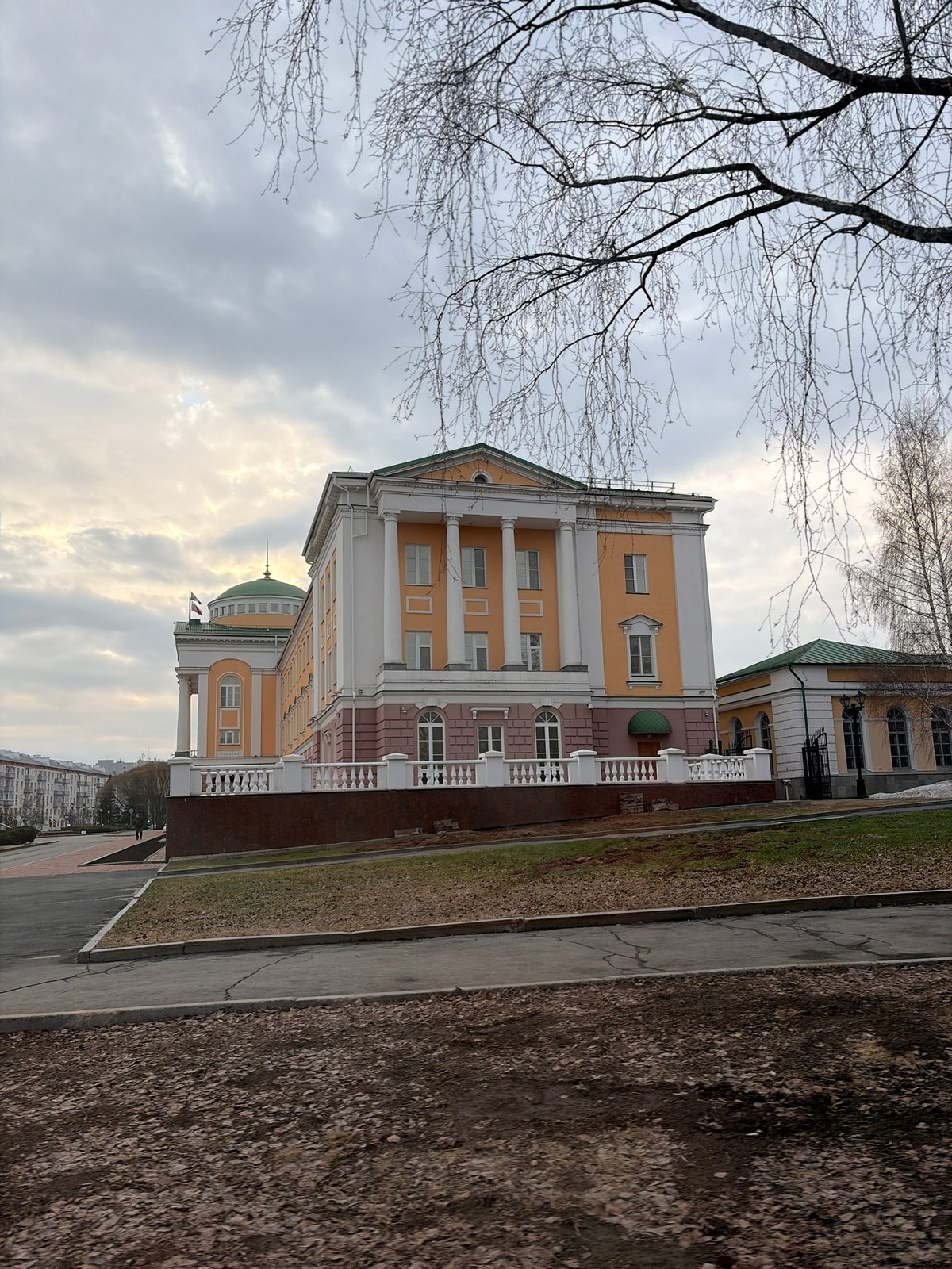 Pedestrian walks past classical building in Izhevsk, Russia