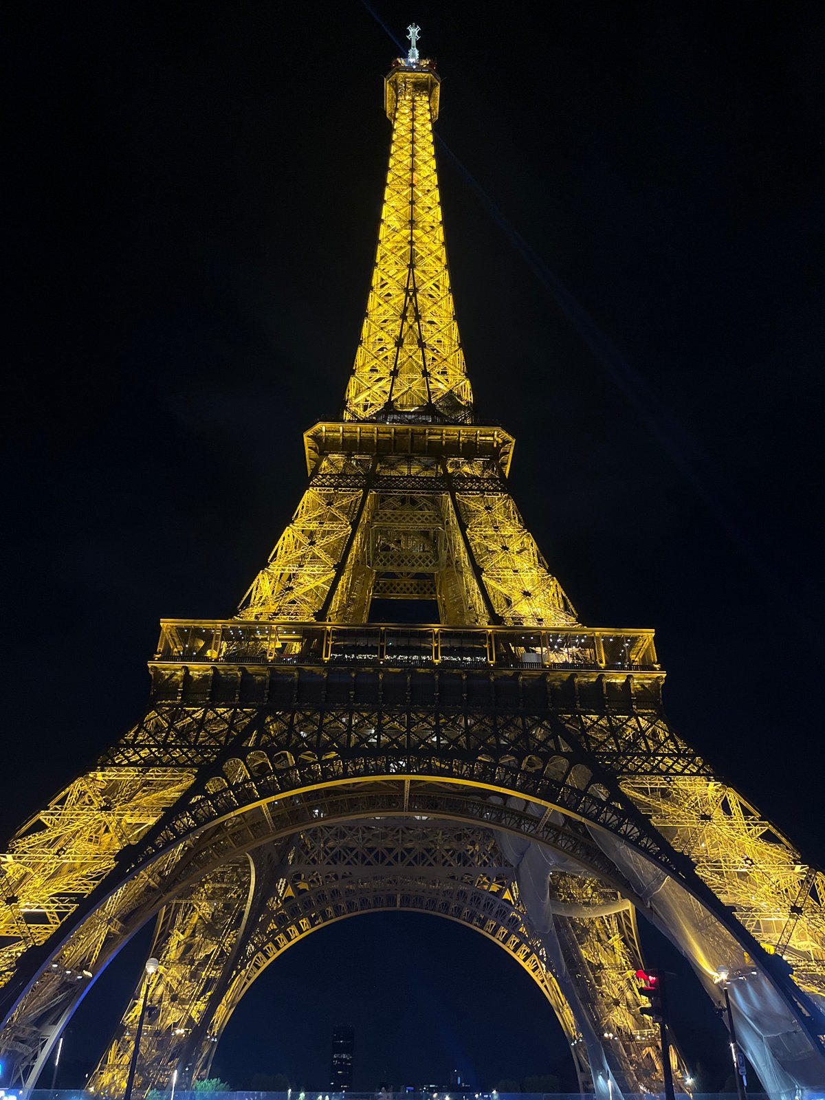 Eiffel Tower displays golden nighttime illumination in Paris