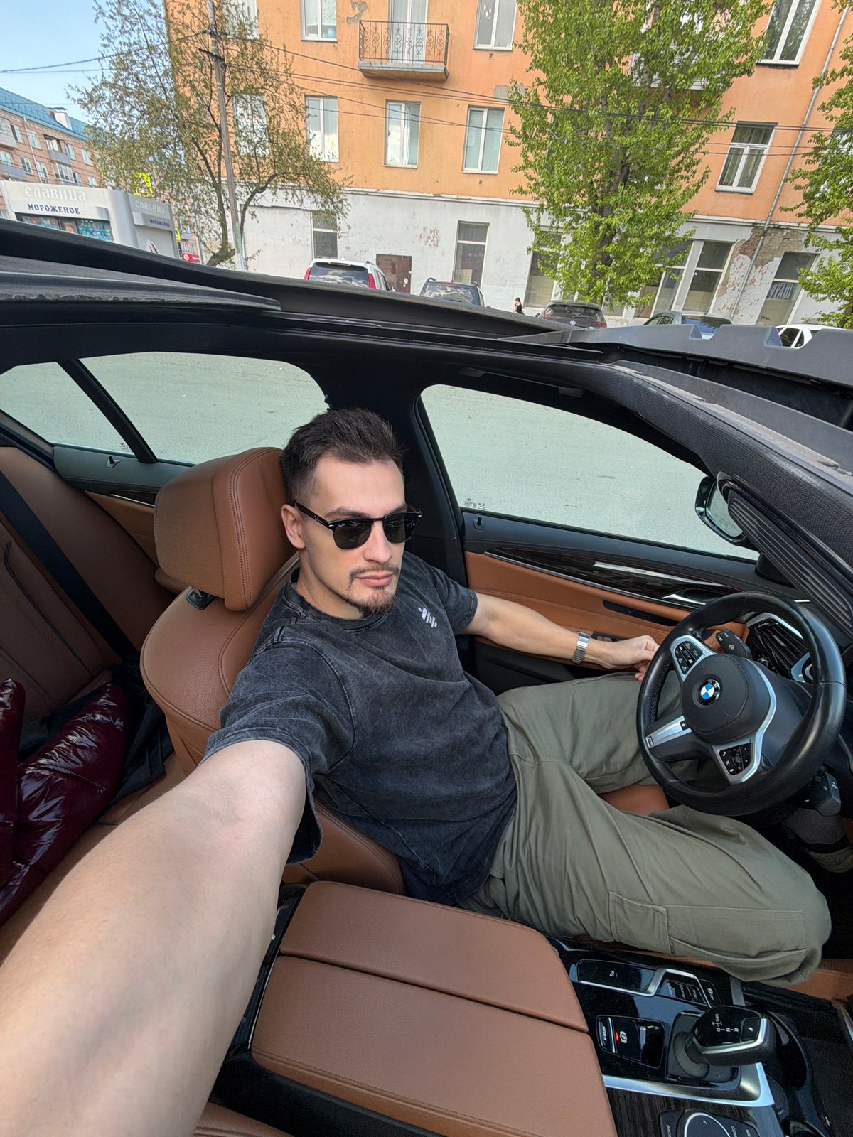 Man reclining in BMW driver's seat in Krasnoyarsk