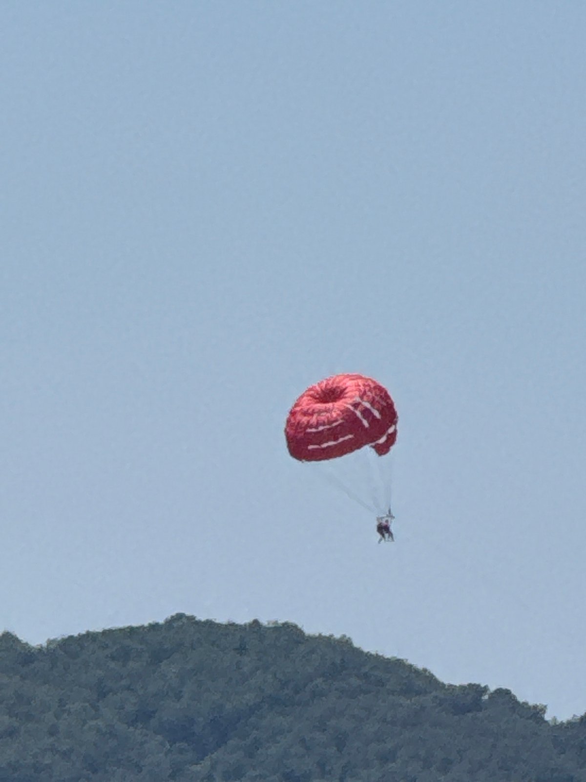 Parasailing and paragliding over Rafailovići on a clear summer day