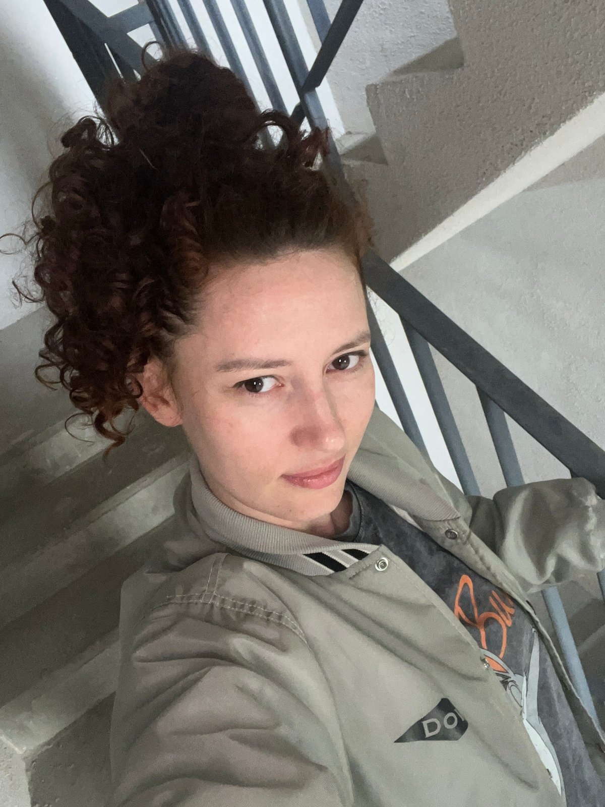 Person in bomber jacket sits on steps in Saint Petersburg