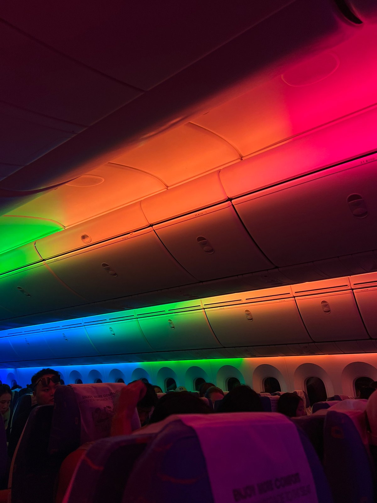 Rainbow LED lighting fills an airplane cabin at night