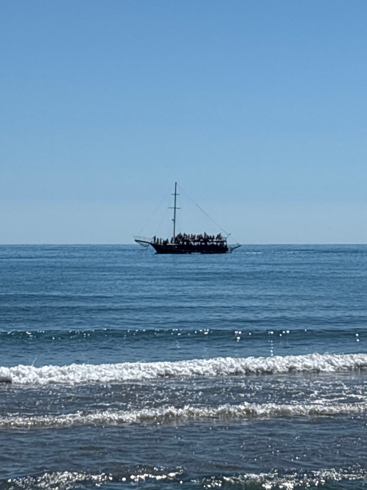 A sun-soaked beach day with boats, sand, and coastal views
