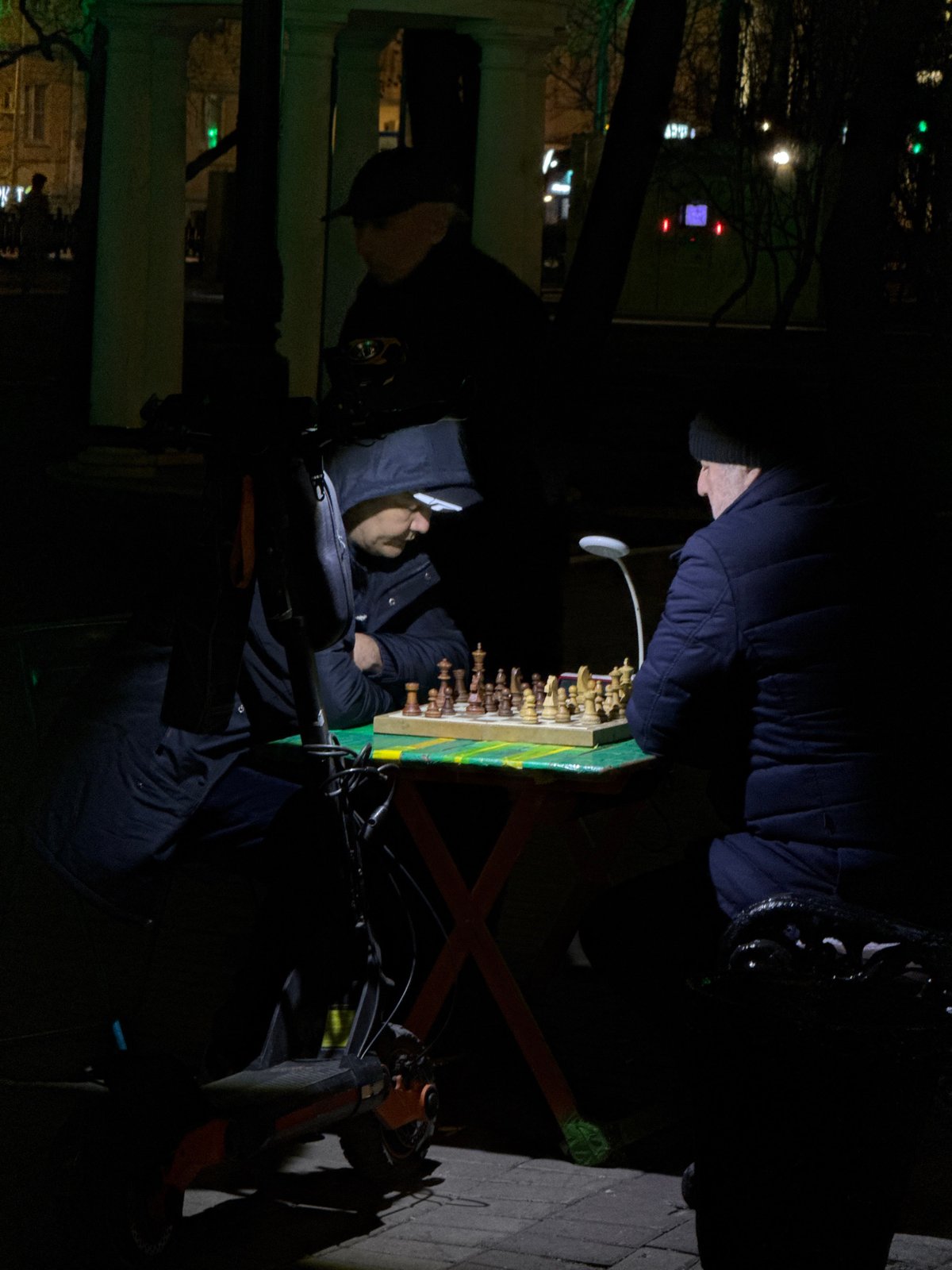 Nighttime chess match observed in Moscow street setting