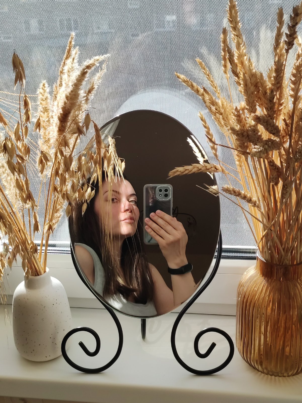 Woman takes mirror selfie on windowsill in Chaikovsky, Russia