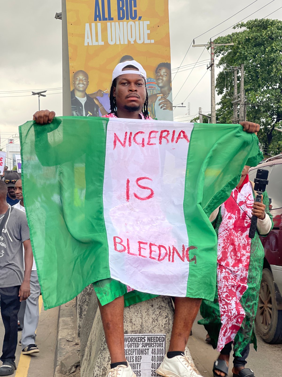 Man displays modified Nigerian flag with protest message in Ikeja