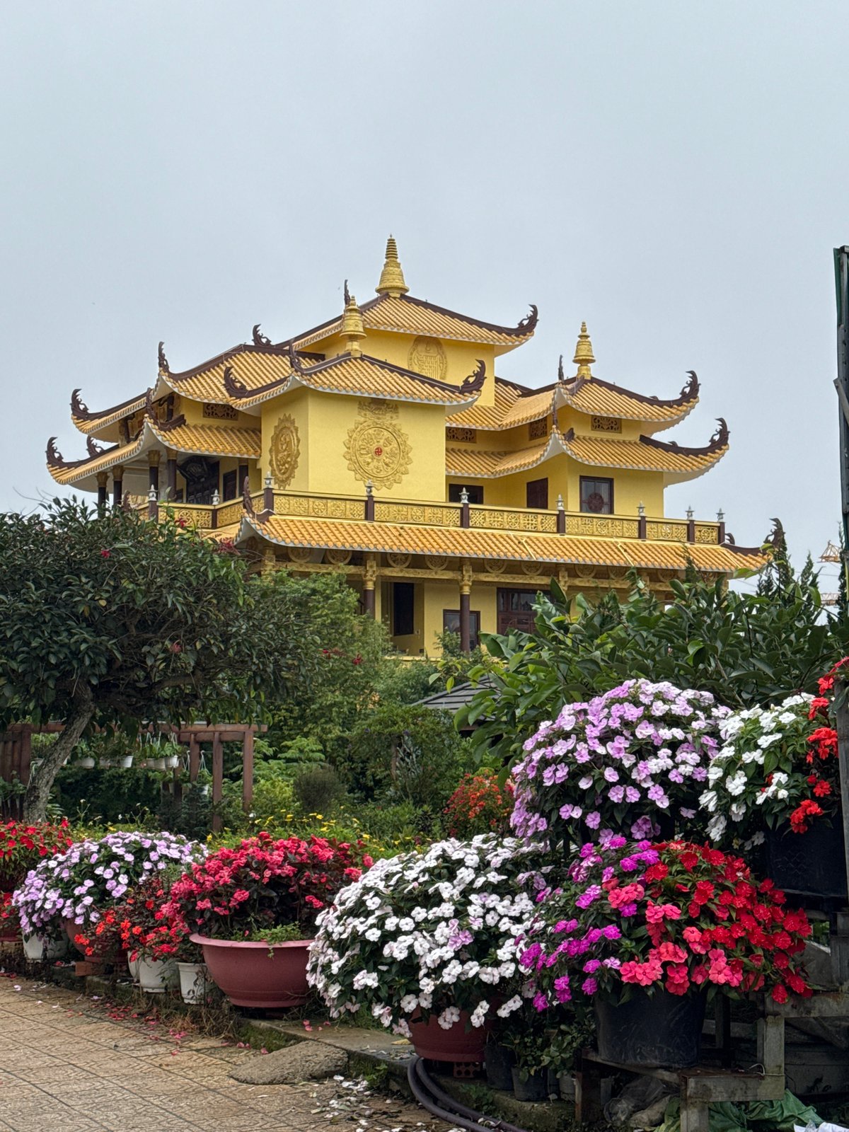 Ornate Buddhist temple and flower-lined walkway in Da Lat