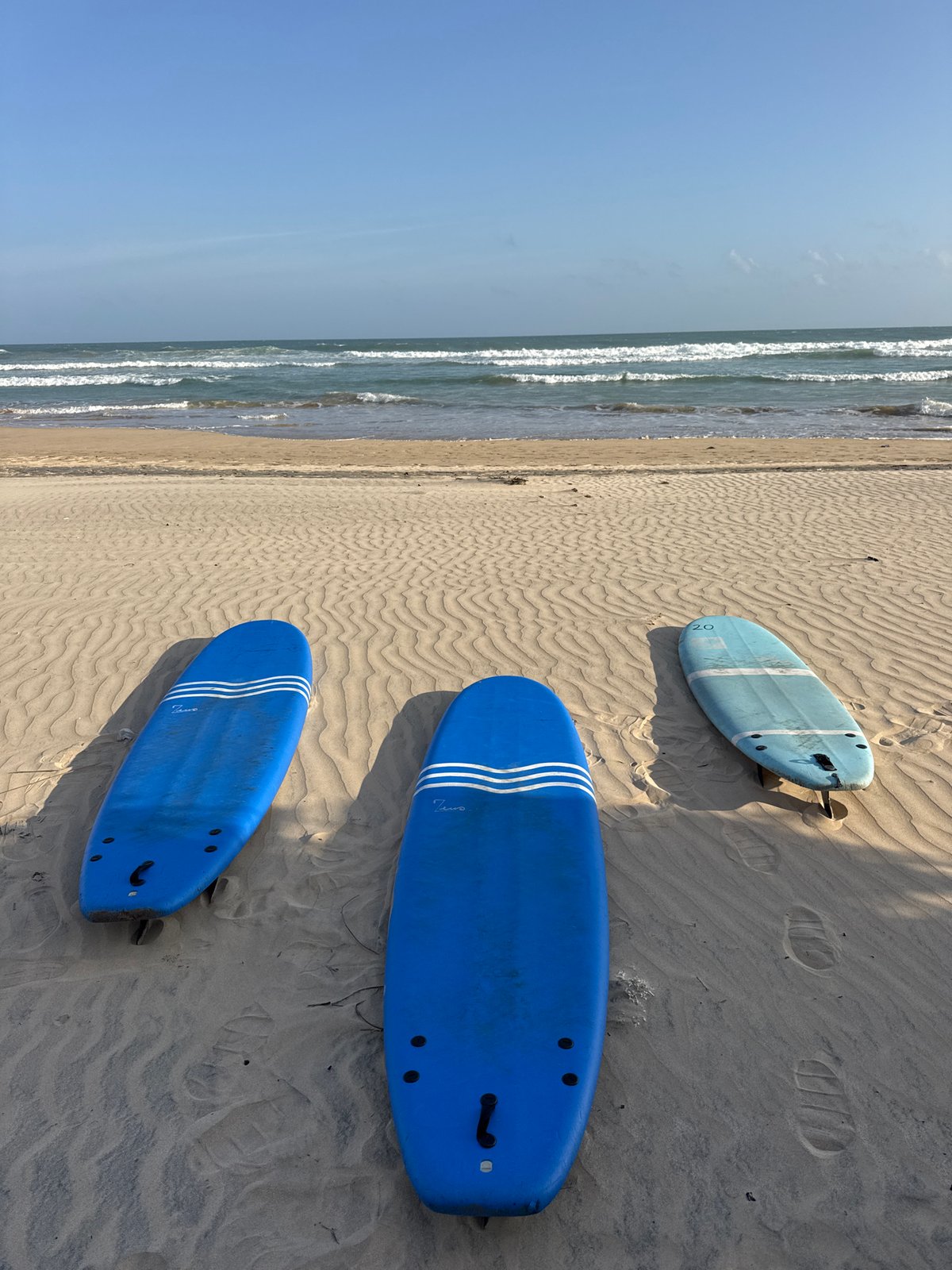 Three blue surfboards on a Sri Lankan beach