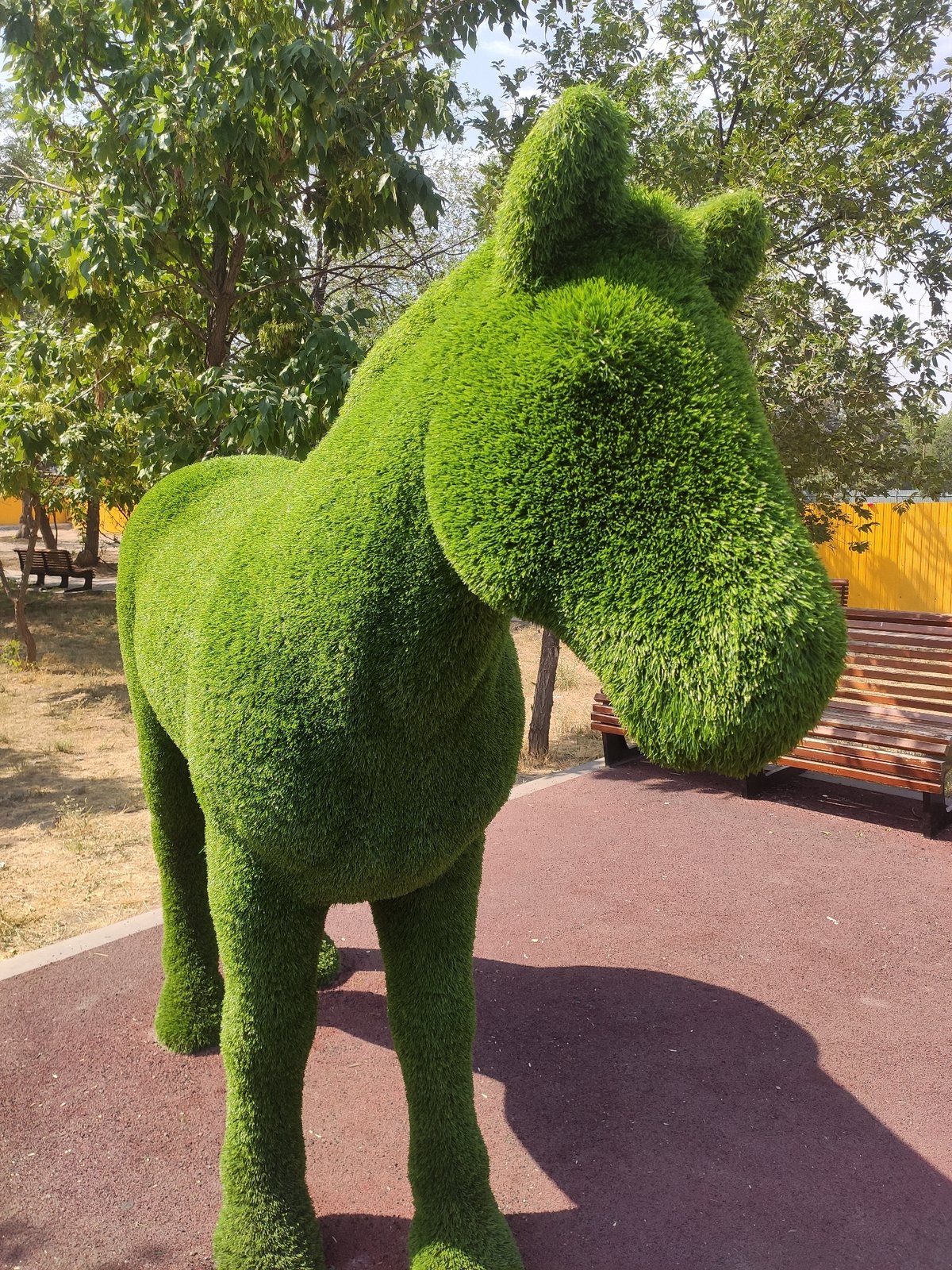 Yerevan park with topiary sculptures, monuments, and active construction