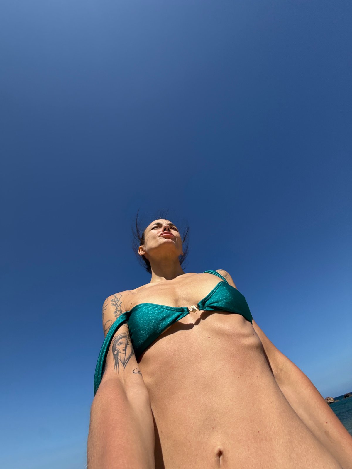 Woman sunbathes on crowded beach in Chania, Greece