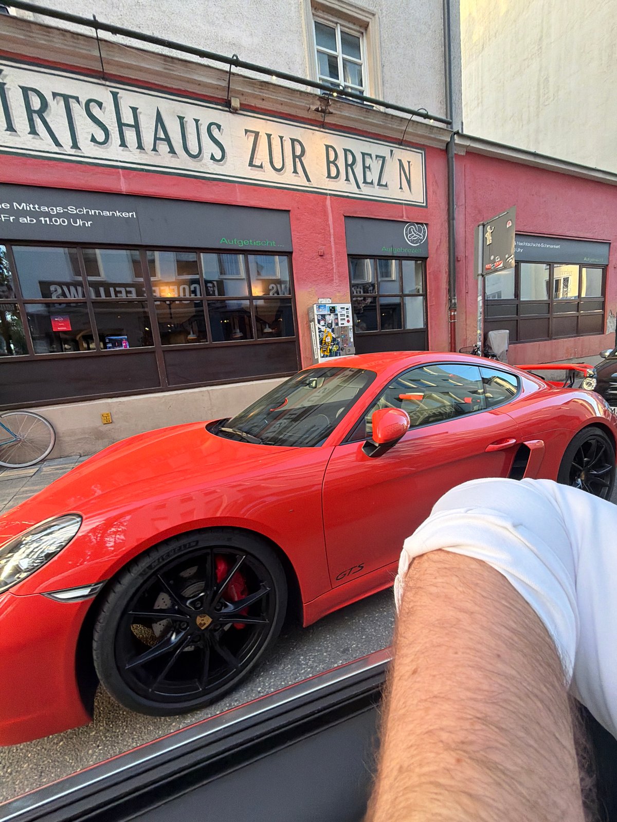 Red Porsche, local shops, and Munich streets on a summer evening