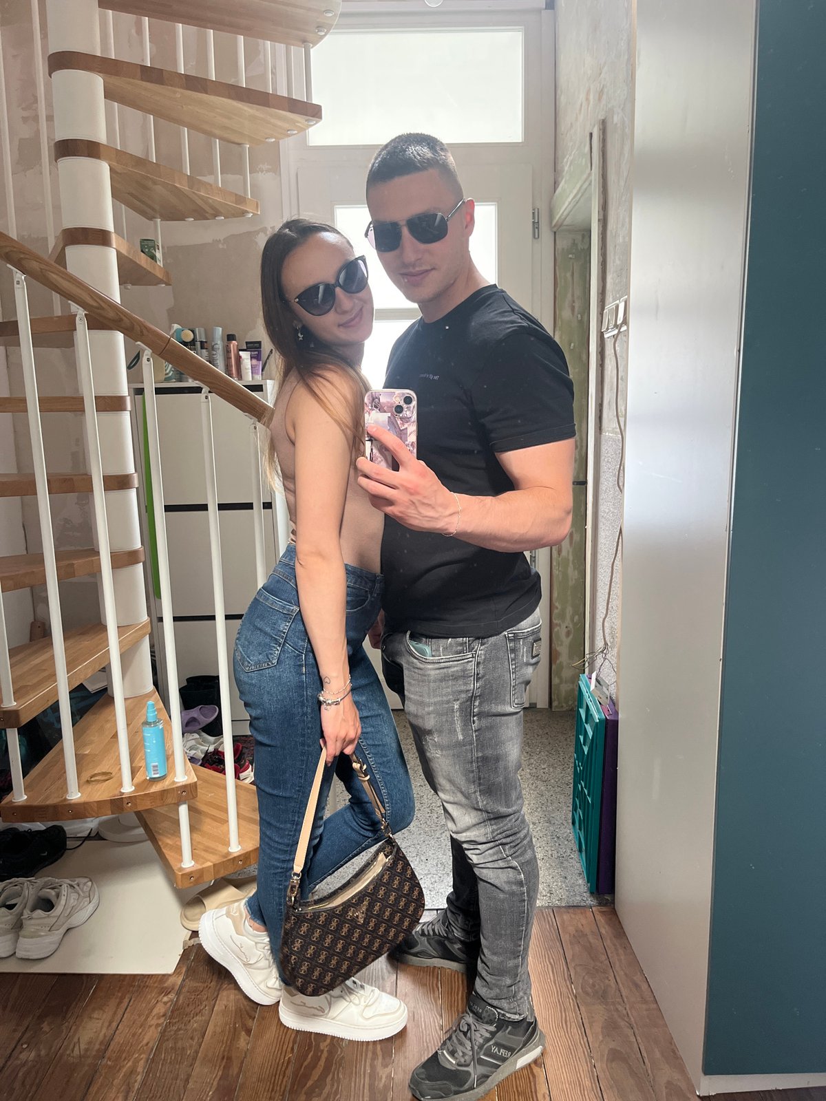Couple takes mirror selfies in Saarbrücken hallway