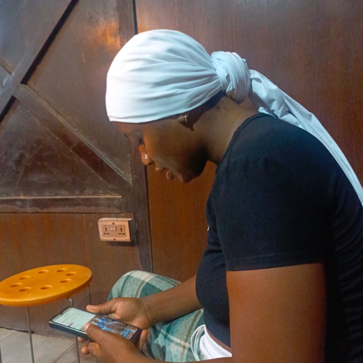 Person in headscarf uses smartphone indoors for brief period