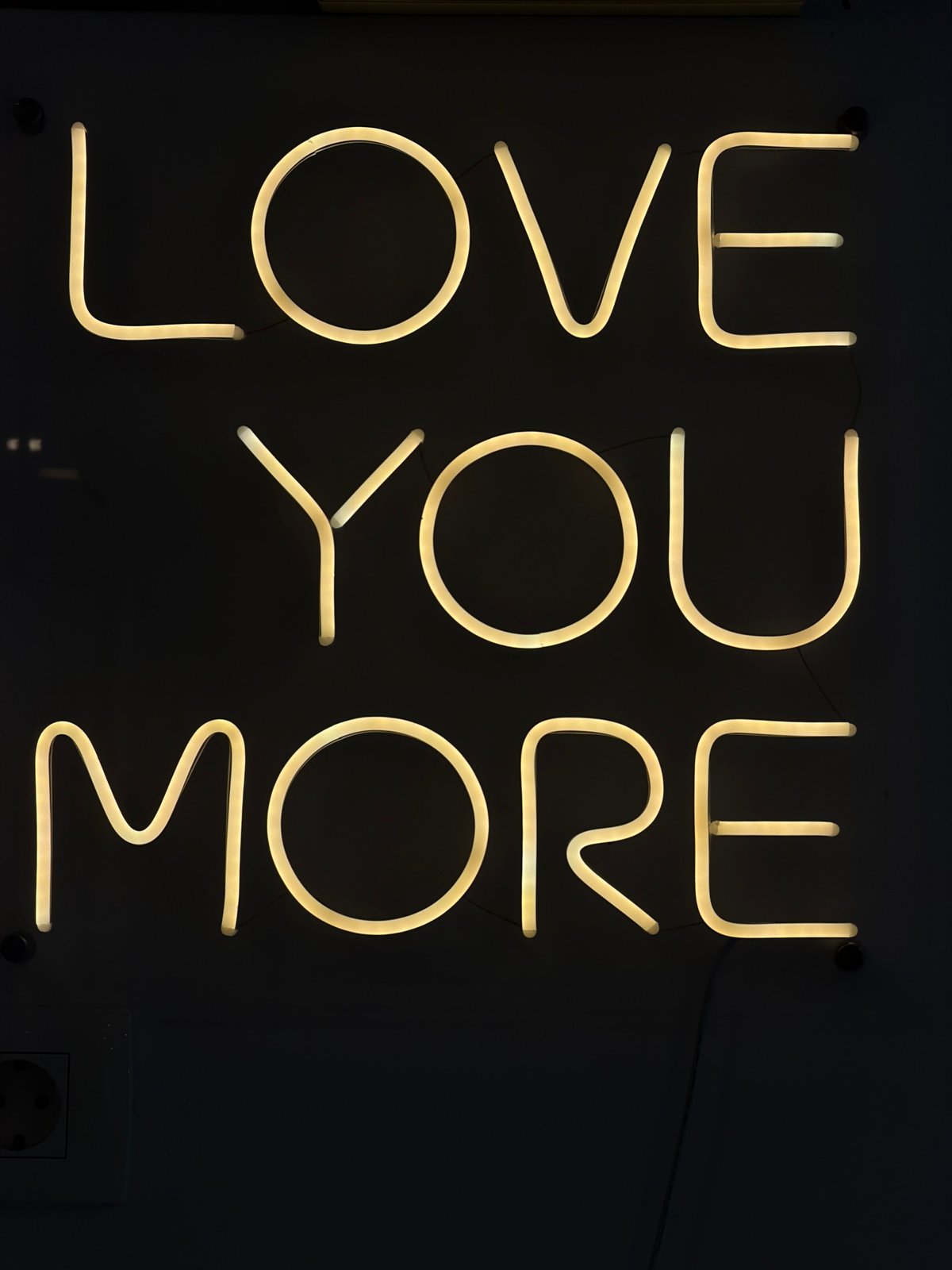 Neon signs including "LOVE YOU MORE" message documented