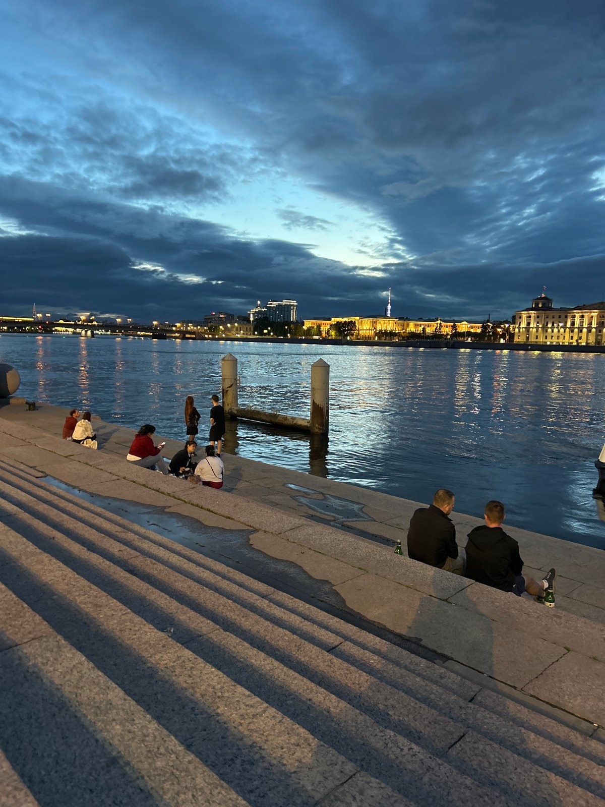 Urban waterfront evening gathering captured by witnesses at dusk