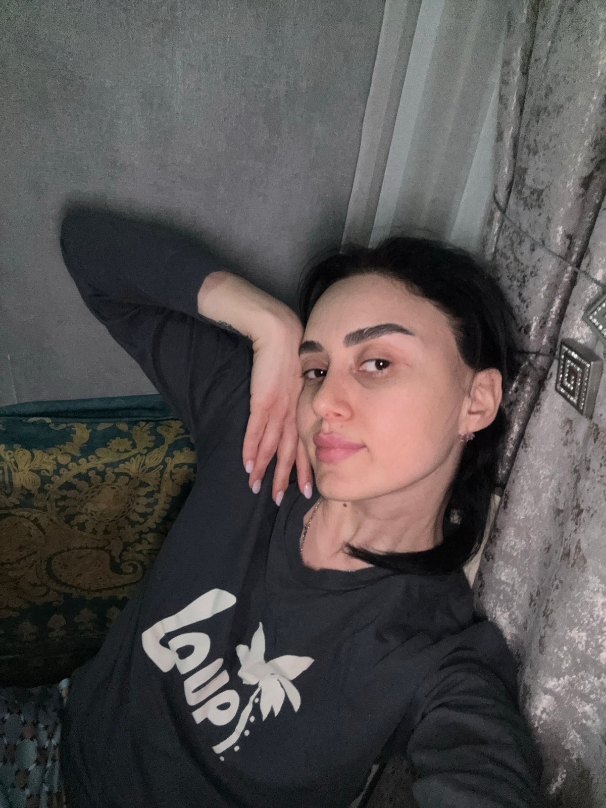 Woman rests indoors during evening photo session in Tbilisi