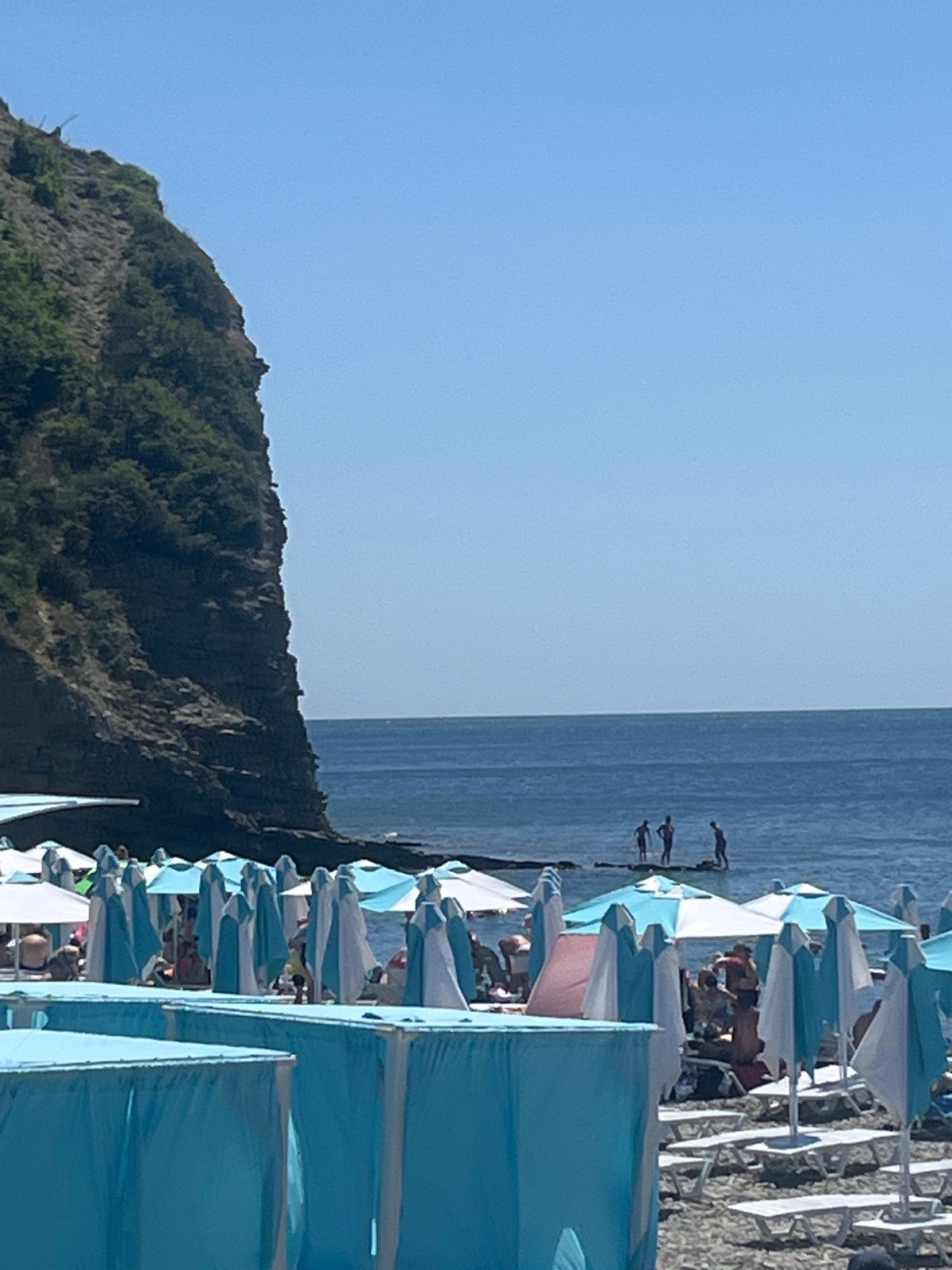 Sunny beach day with umbrellas, lounge chairs, and lifeguard post