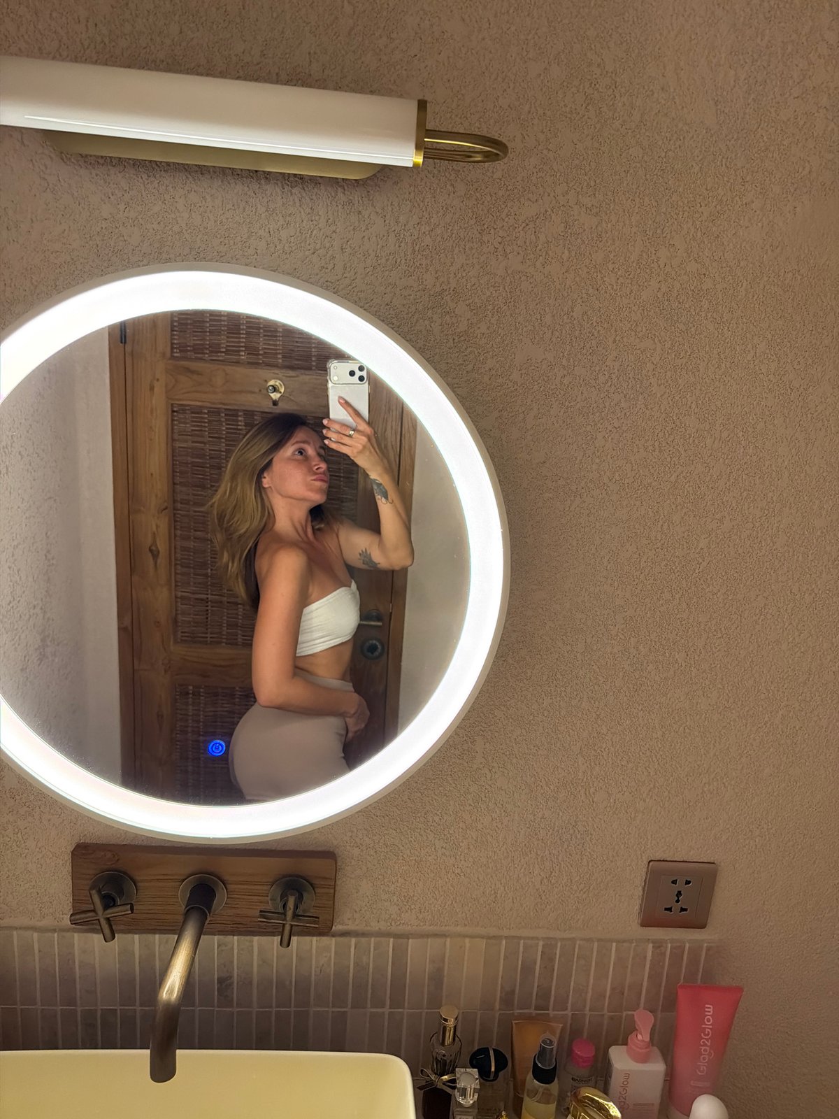 Woman takes mirror selfies in Mengwi bathroom area