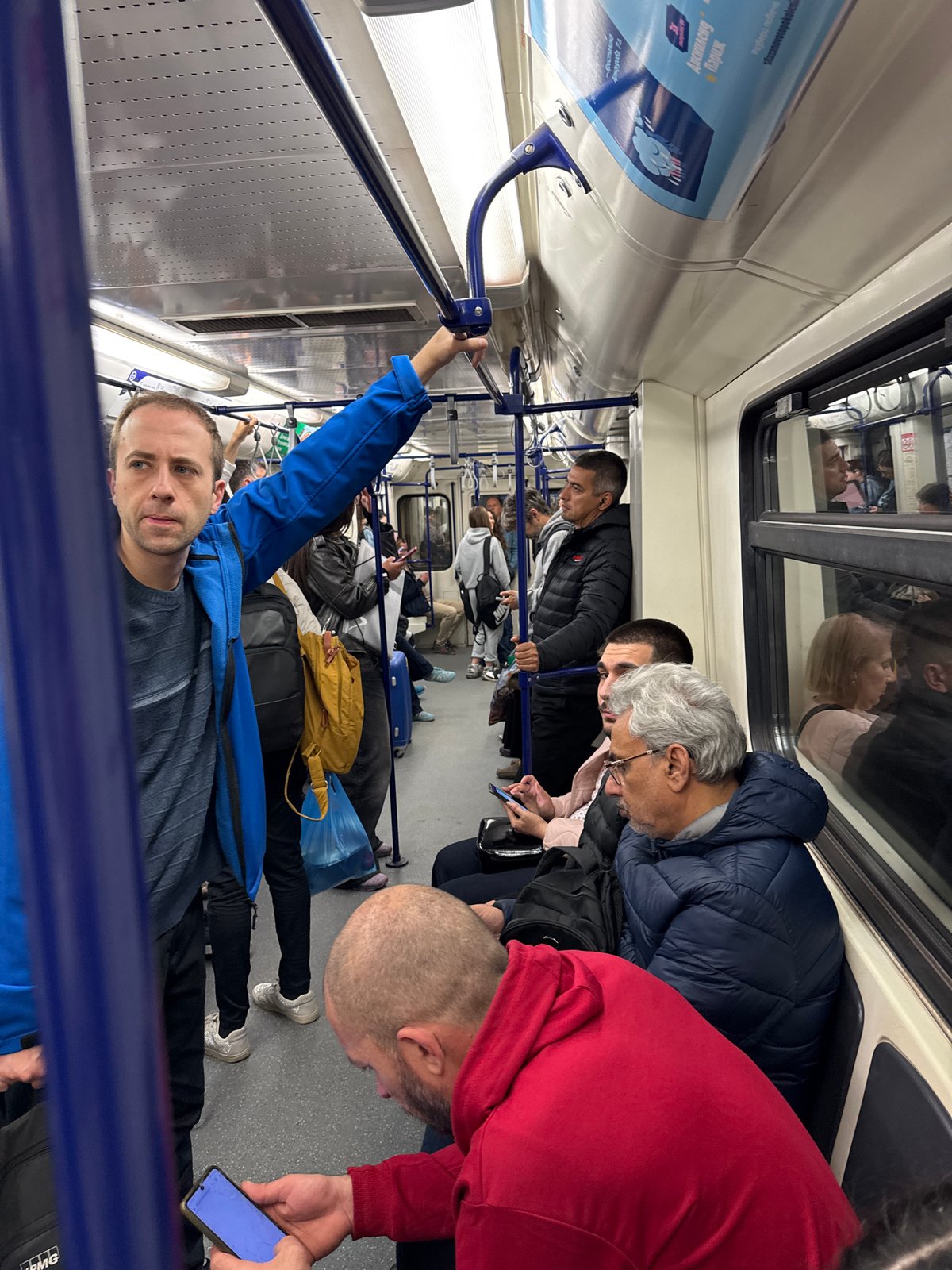 Commuters check phones during subway ride in Sofia