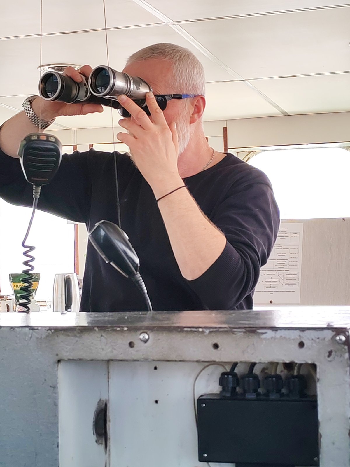 Man with binoculars observed near waterside church in Koprino