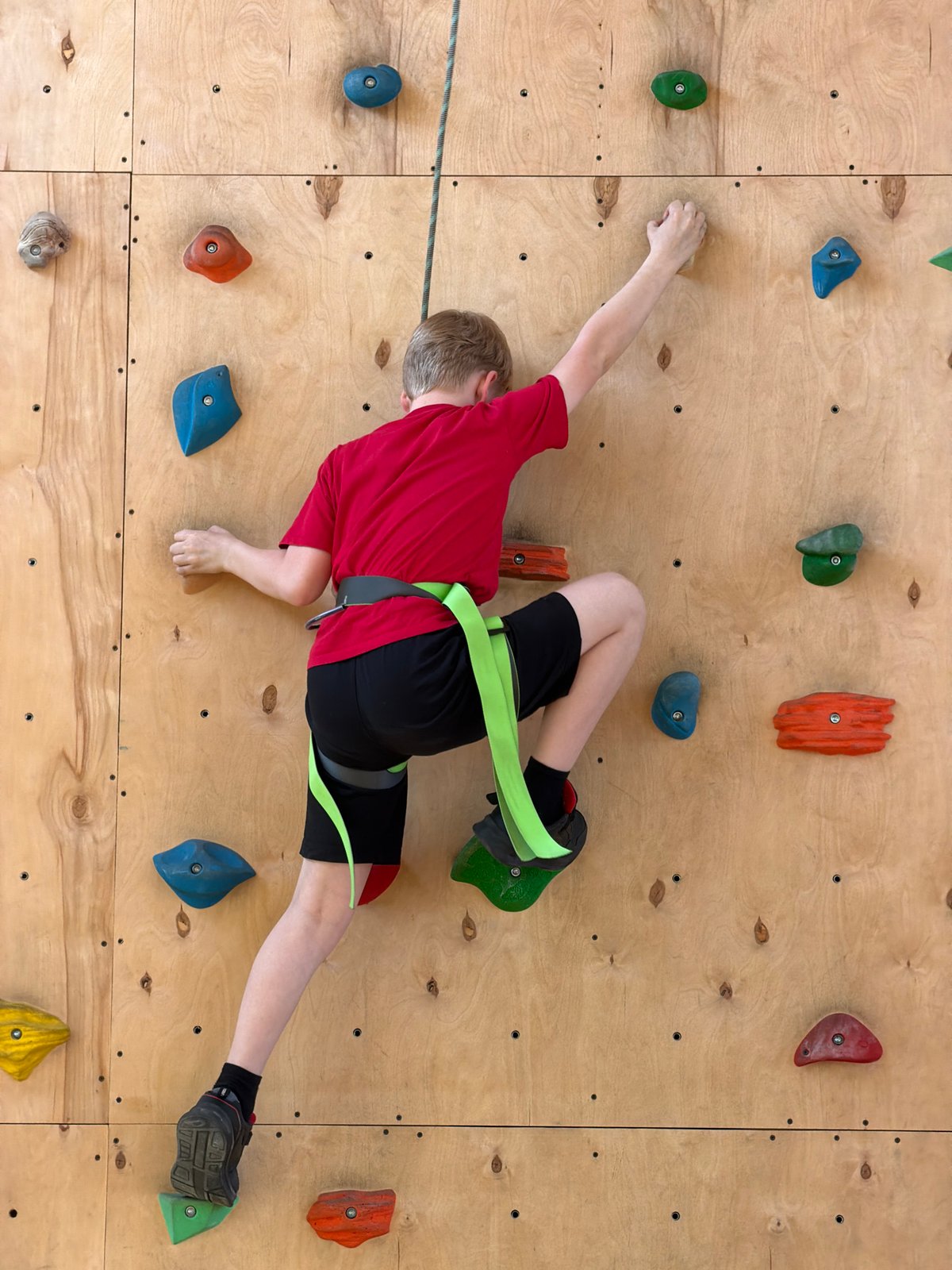 Young climber scales rock wall in Izhevsk, Russia
