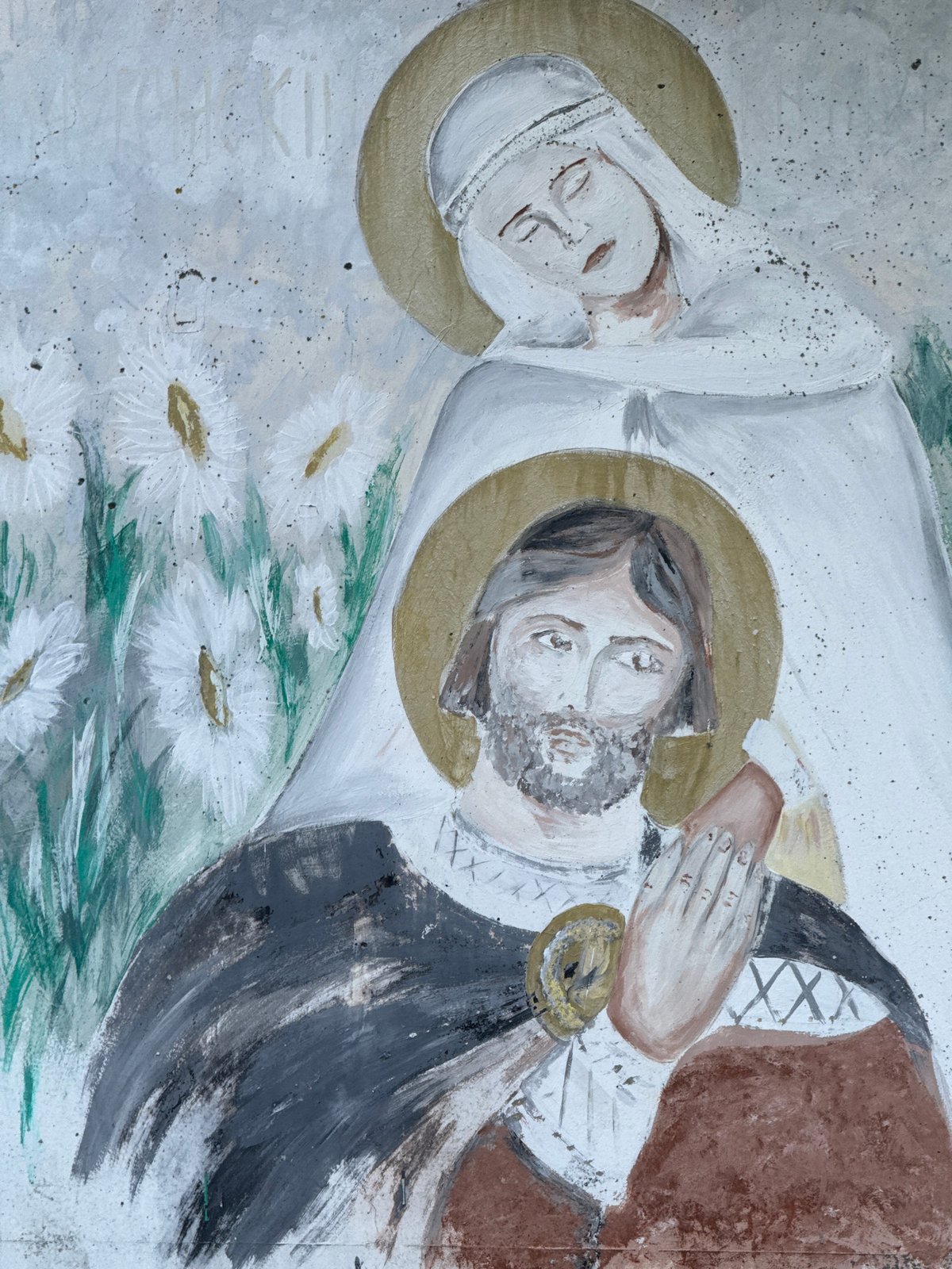 Person holds daisies while viewing religious murals in Murom