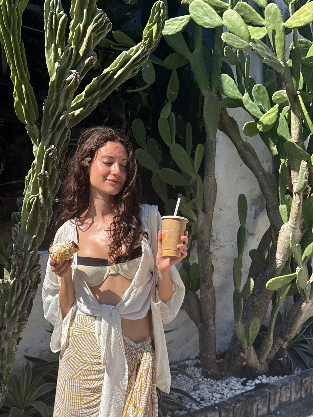 Woman enjoys breakfast among cacti in North Kuta