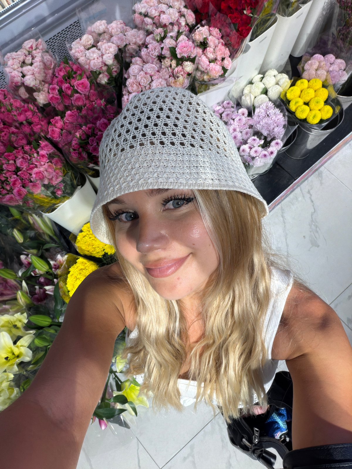 Browsing fresh flower bouquets at a Choeng Thale grocery store