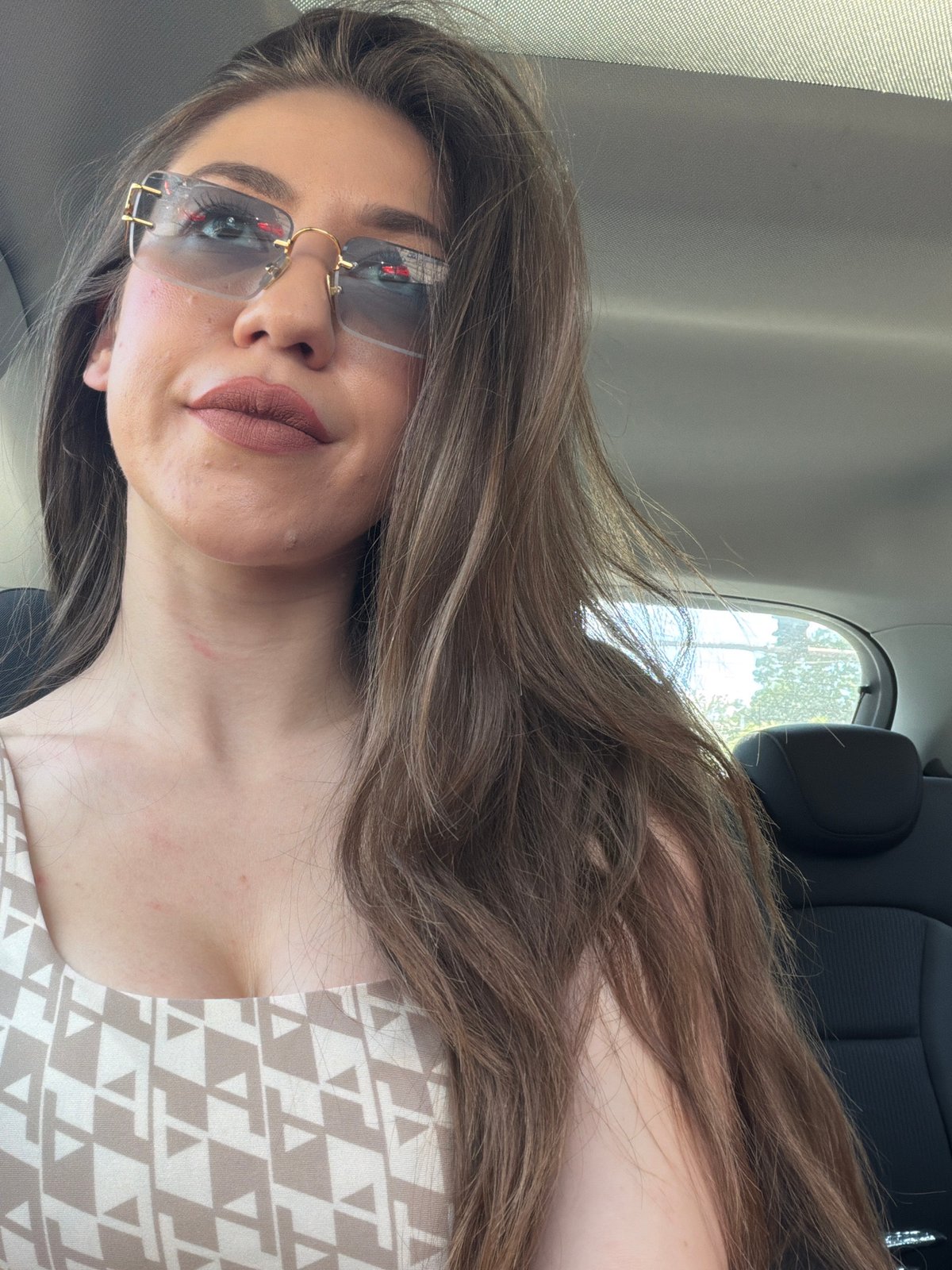 Woman takes car selfies in Sofia wearing sunglasses