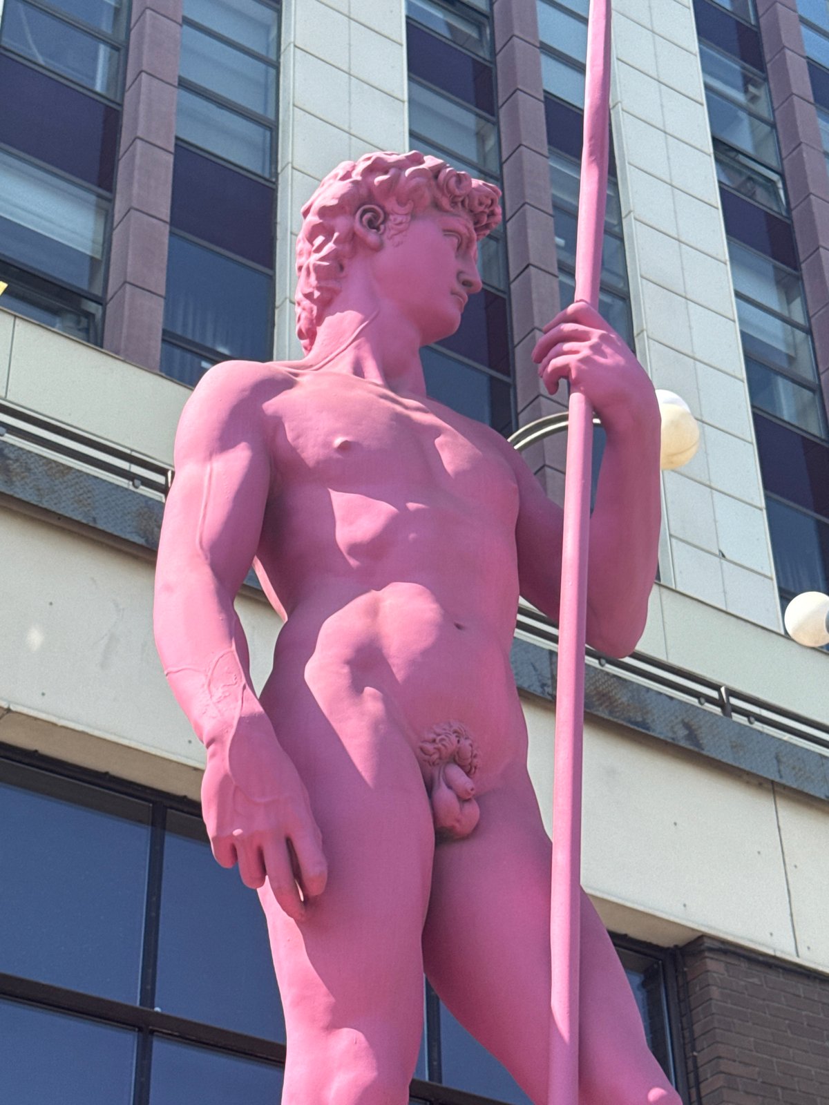 Urban riverside walk: barges, a dam, and a pink statue