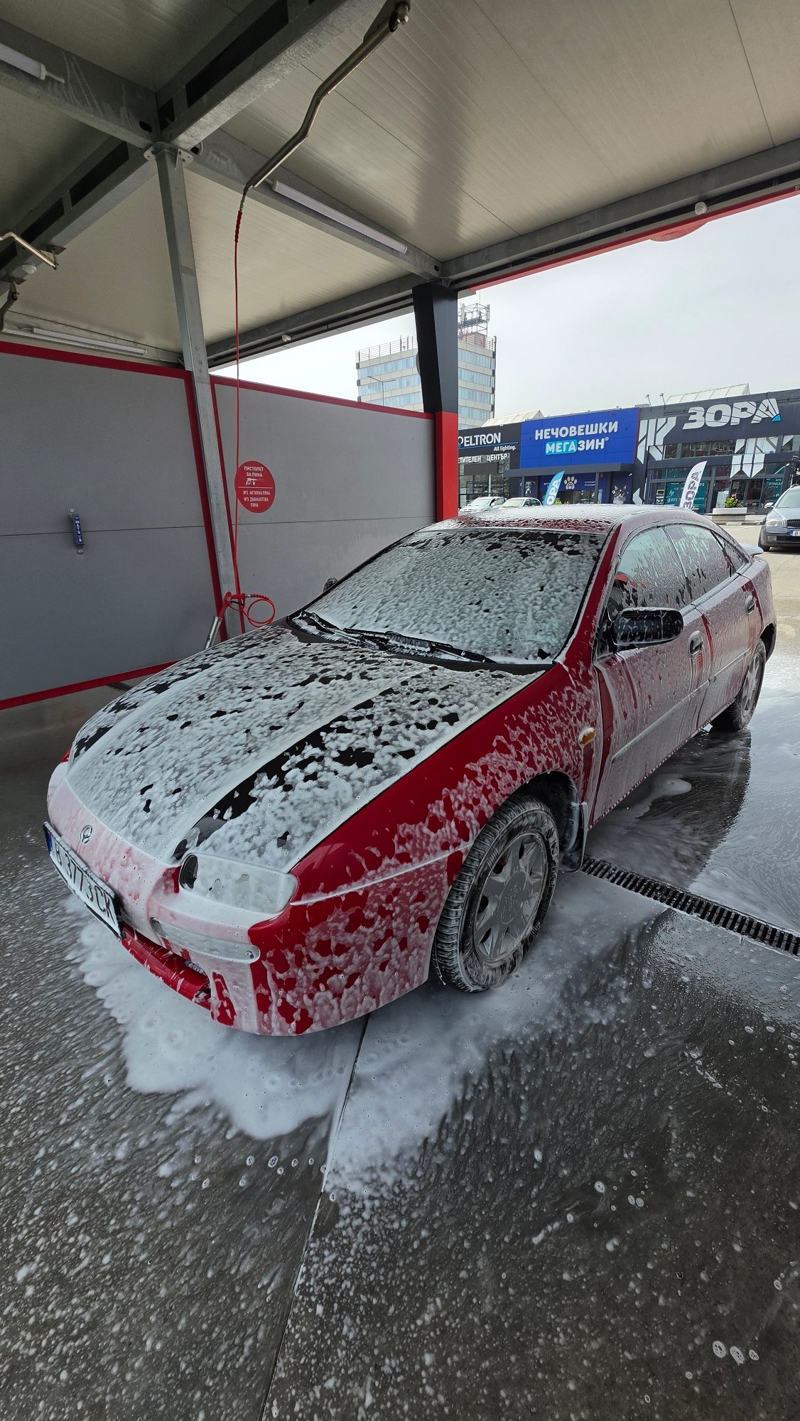 Red car being washed at self-service facility in Varna