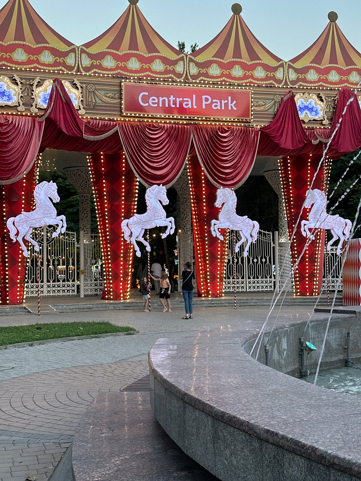 Evening at Tashkent's Central Park — lights, fountains, and a carousel.