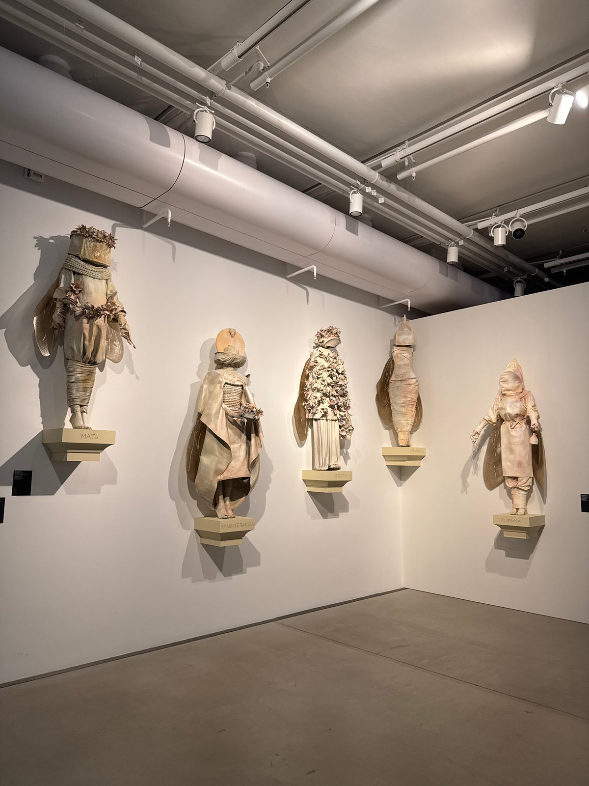 Art exhibition displays doll figures and multi-panel painting in Moscow
