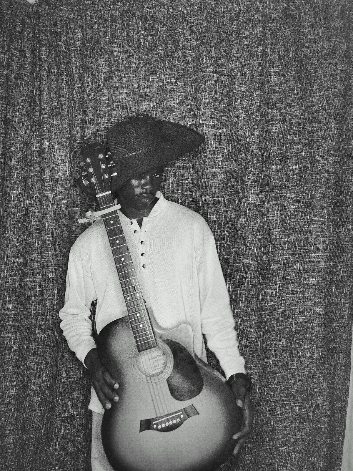 Young guitarist observed in casual portrait session in Keffi