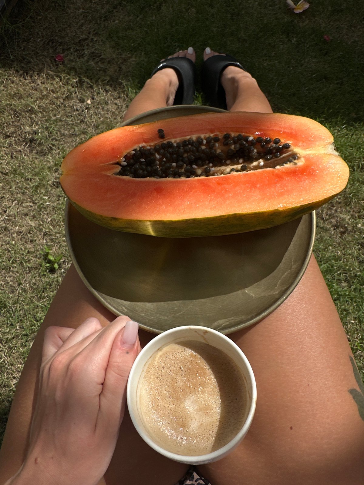 Woman enjoys morning papaya and coffee by pool in Bali