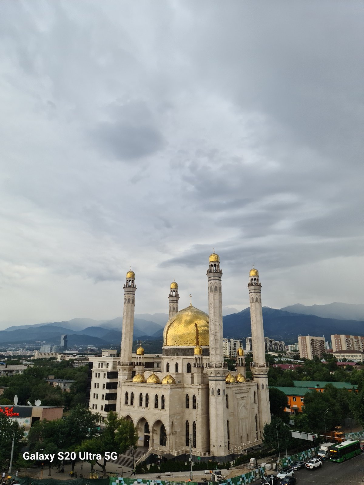 Ornate golden-domed mosque against Almaty's mountain skyline