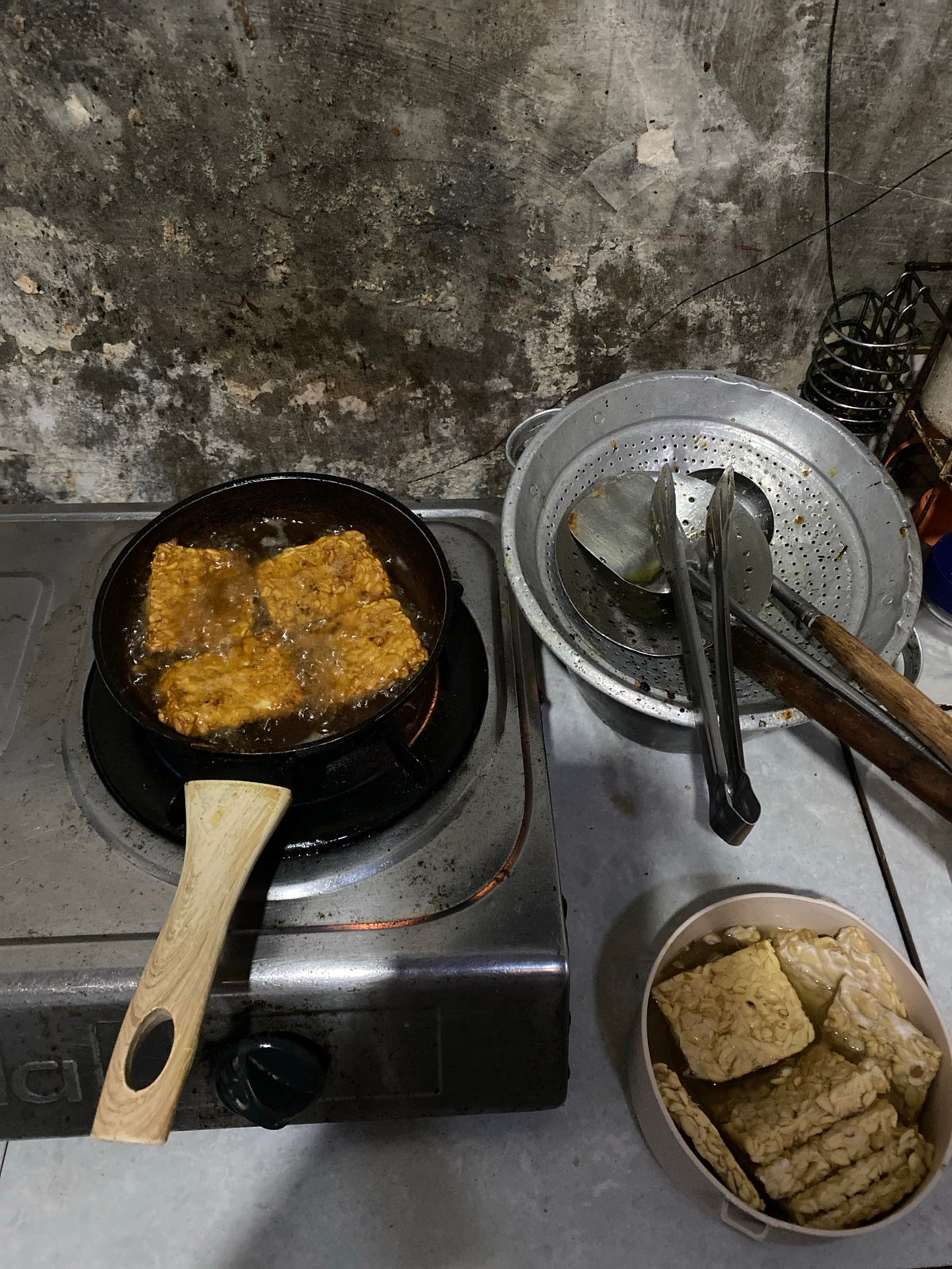 Tempeh frying and eggplant prep in a Madiun home kitchen