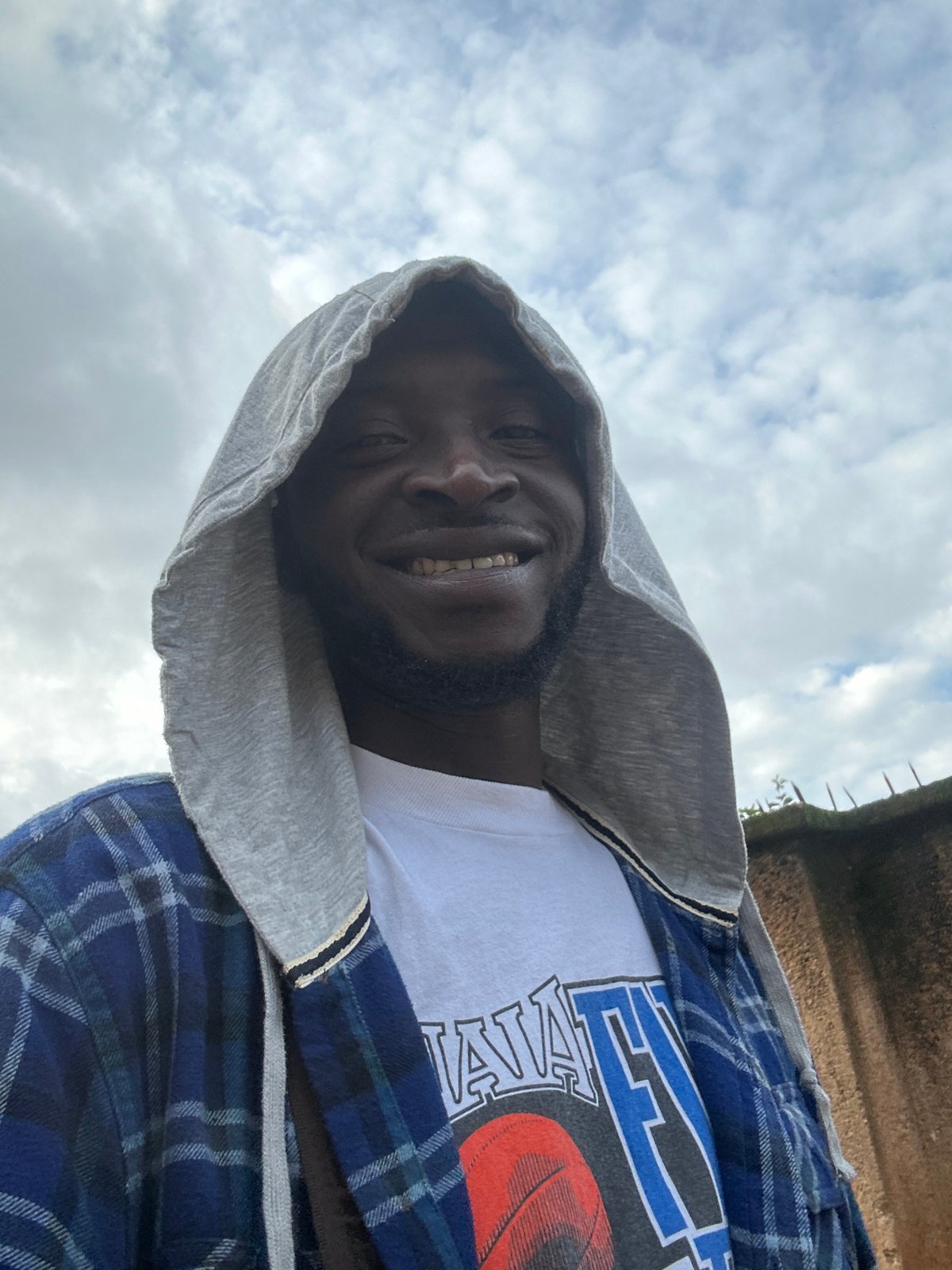 Roadside afternoon in Jos: vendors, jerseys, and a parked van