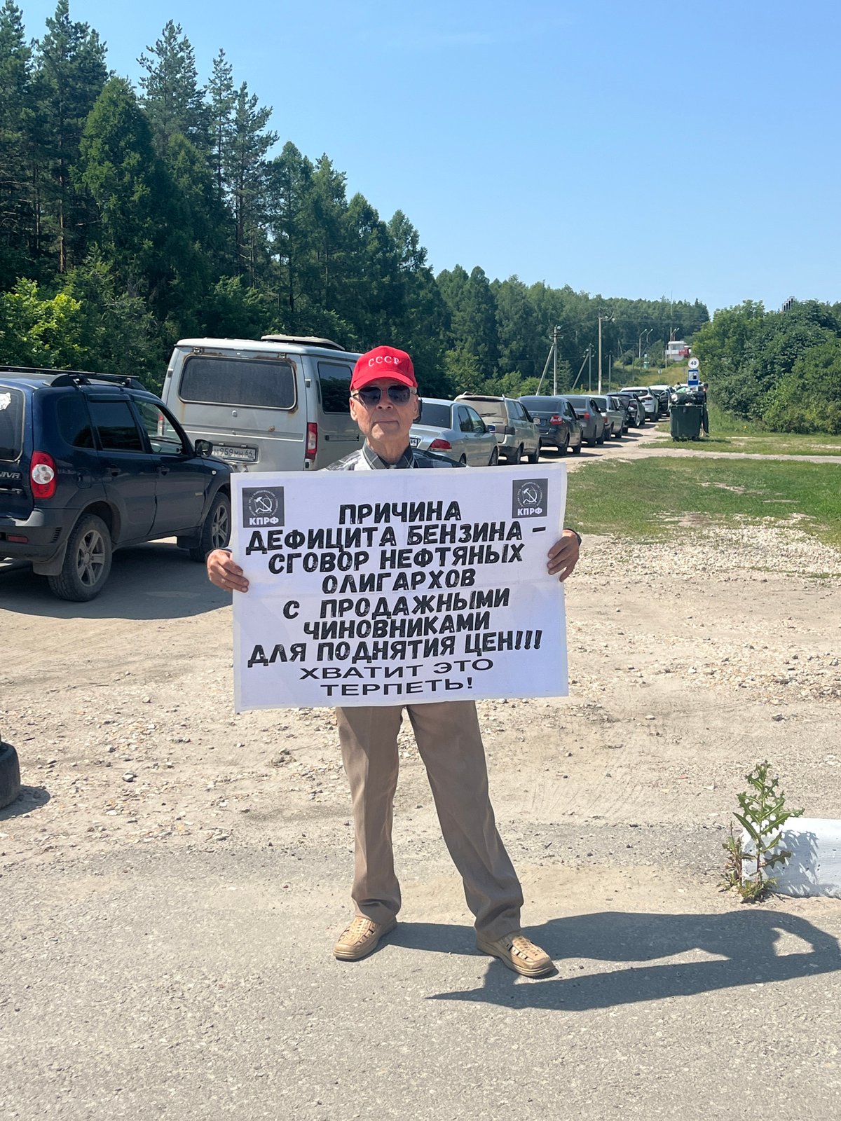 USSR-capped figure holds Cyrillic protest sign at unknown location